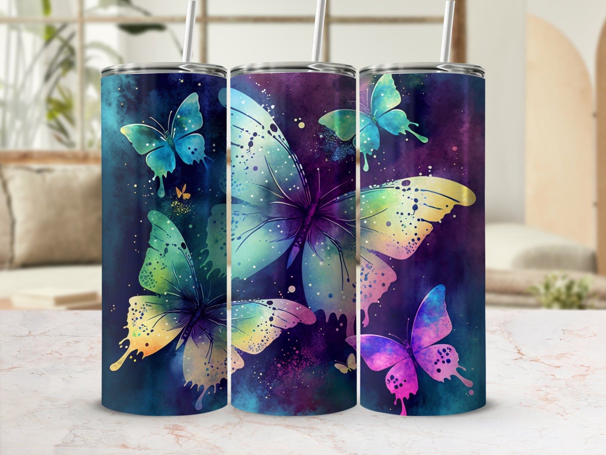 Three tumblers with colorful butterfly and galaxy designs.