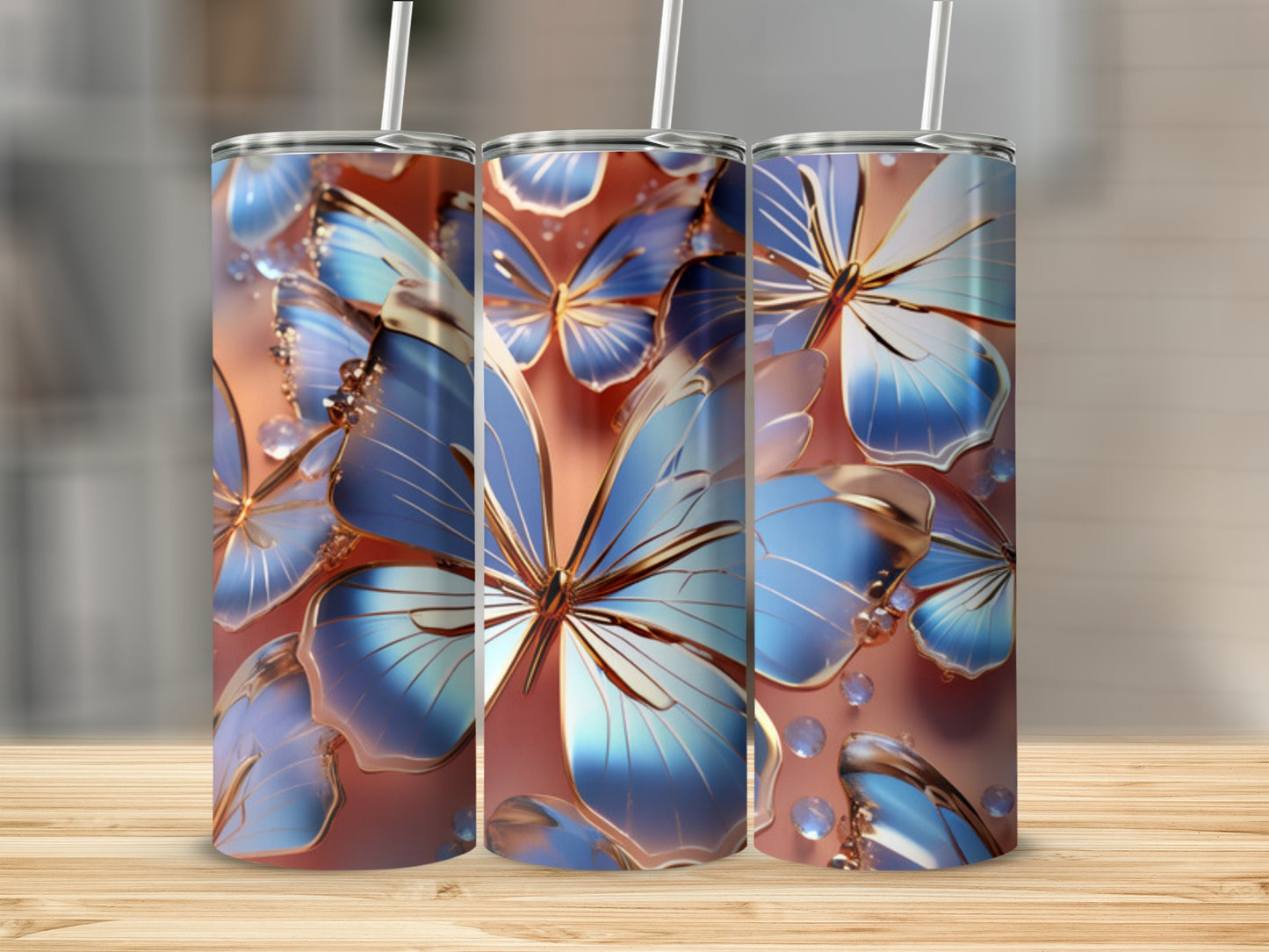 Three tumblers with blue and gold butterfly design on a wooden surface.