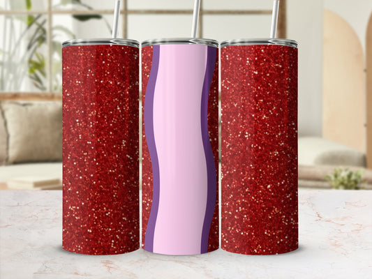 Glittery red and purple tumbler with straw on a marble countertop.