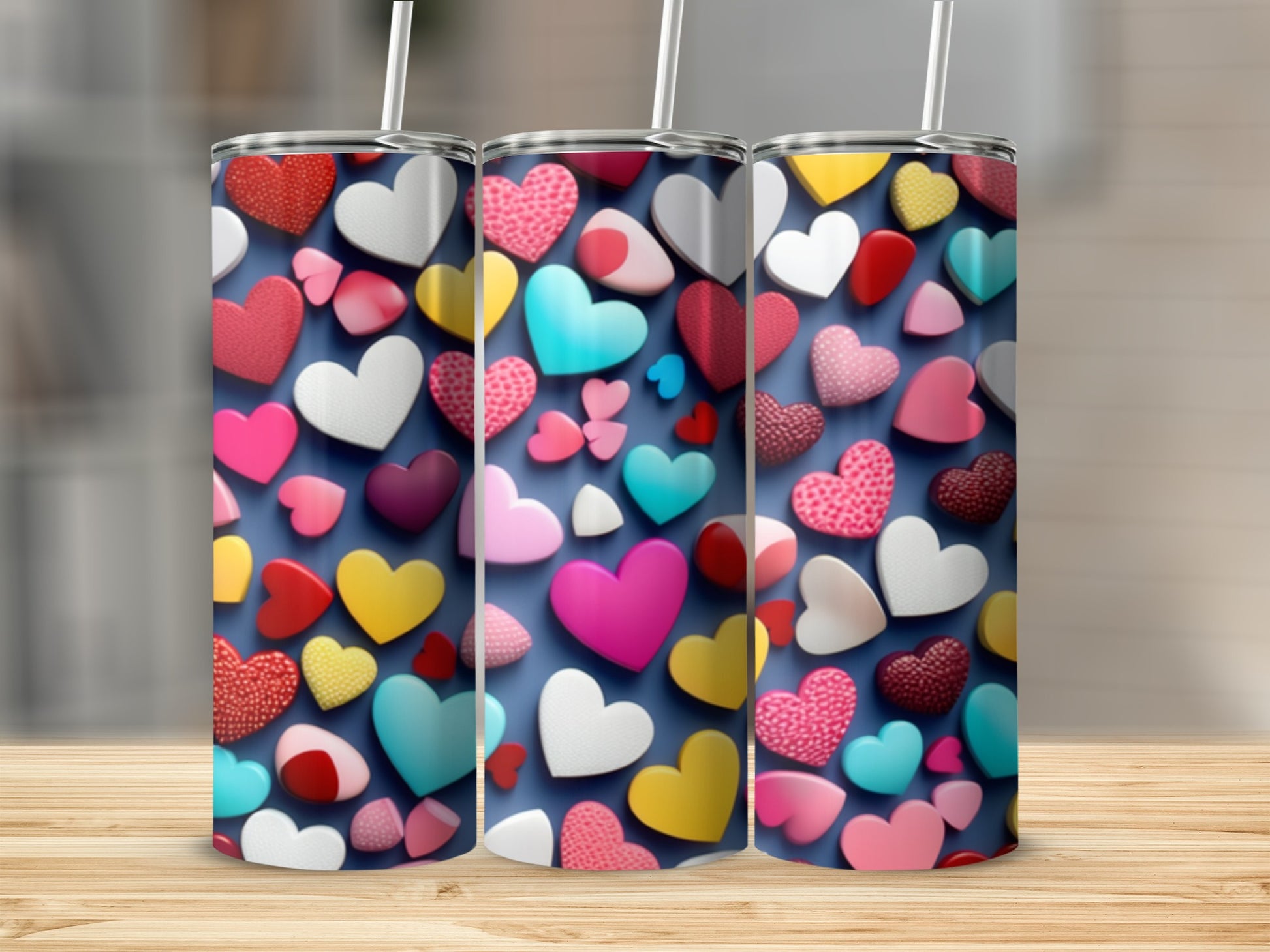 Three tumblers with a colorful heart pattern on a wooden surface.