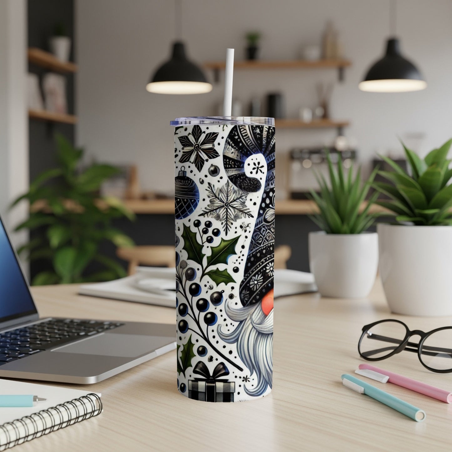 Christmas gnome tumbler with festive pattern and straw on a desk.