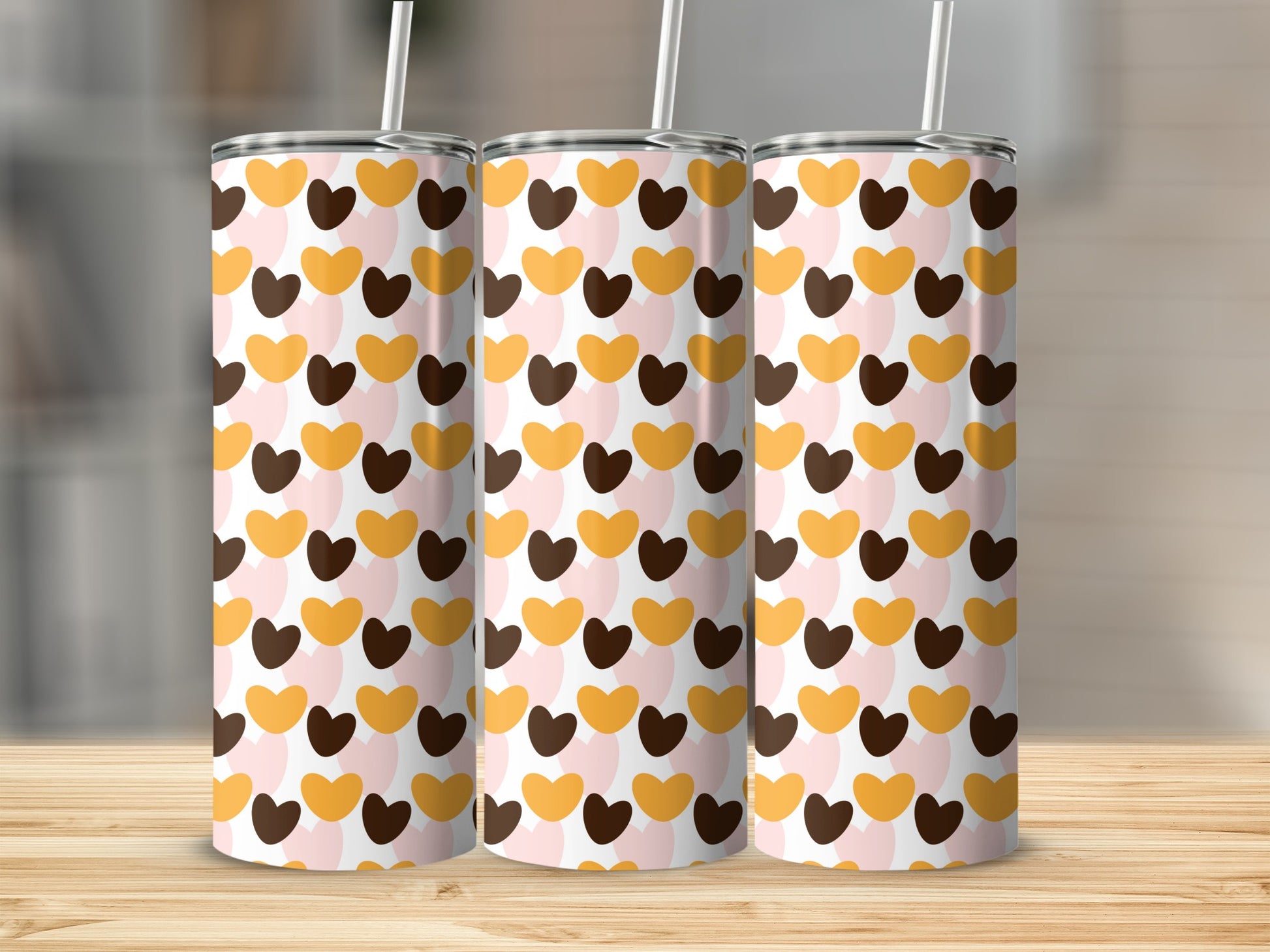 Three tall tumblers with a repeating pattern of pink, brown, and gold hearts.