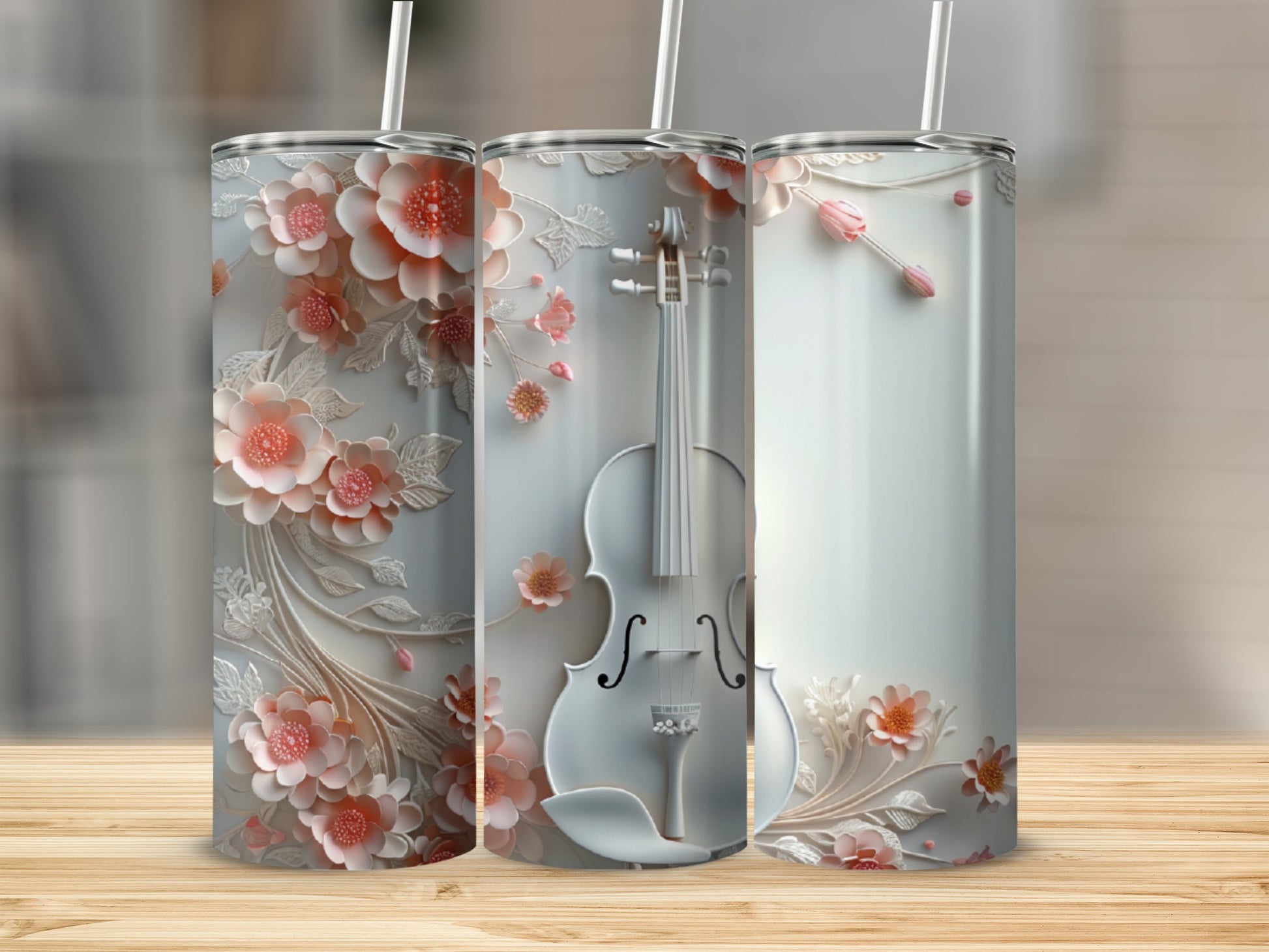 Three tumblers: one with floral design, one with a violin, one with floral accents.