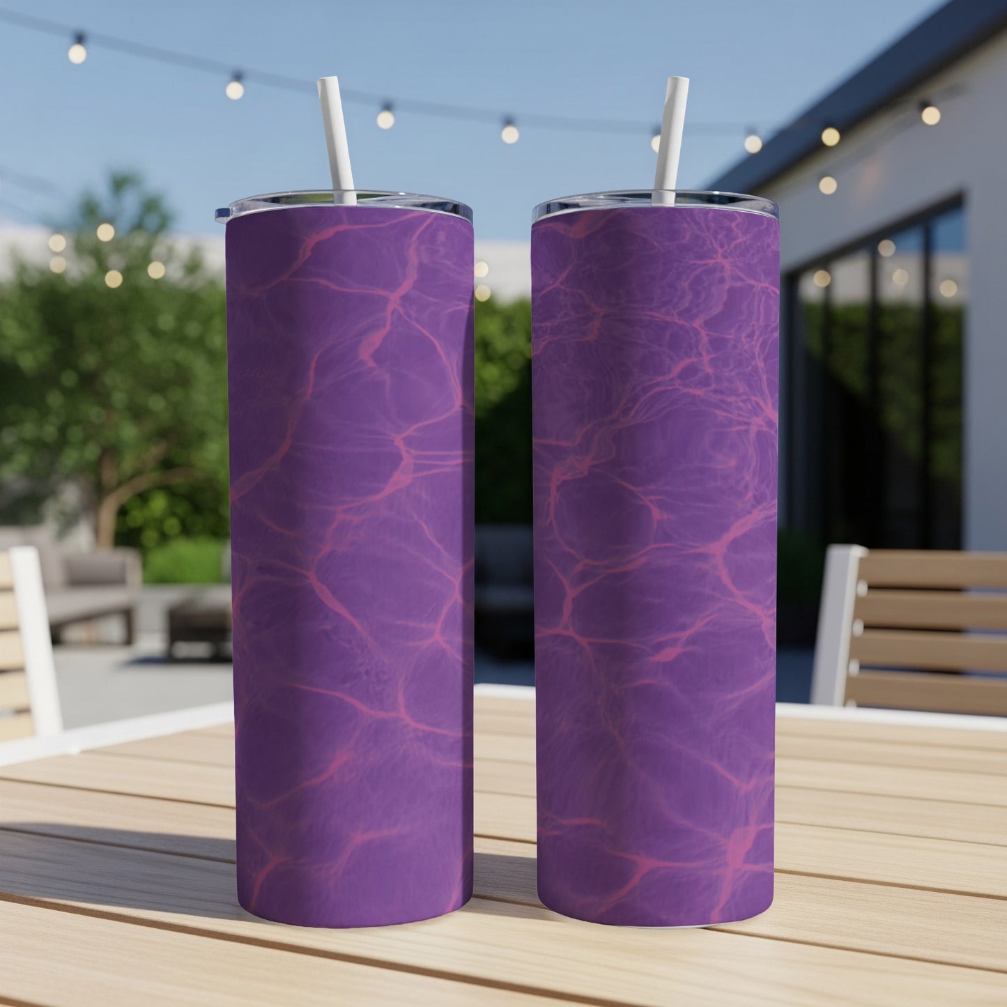 Two purple tumblers with a water ripple pattern sit on a wooden table outdoors.