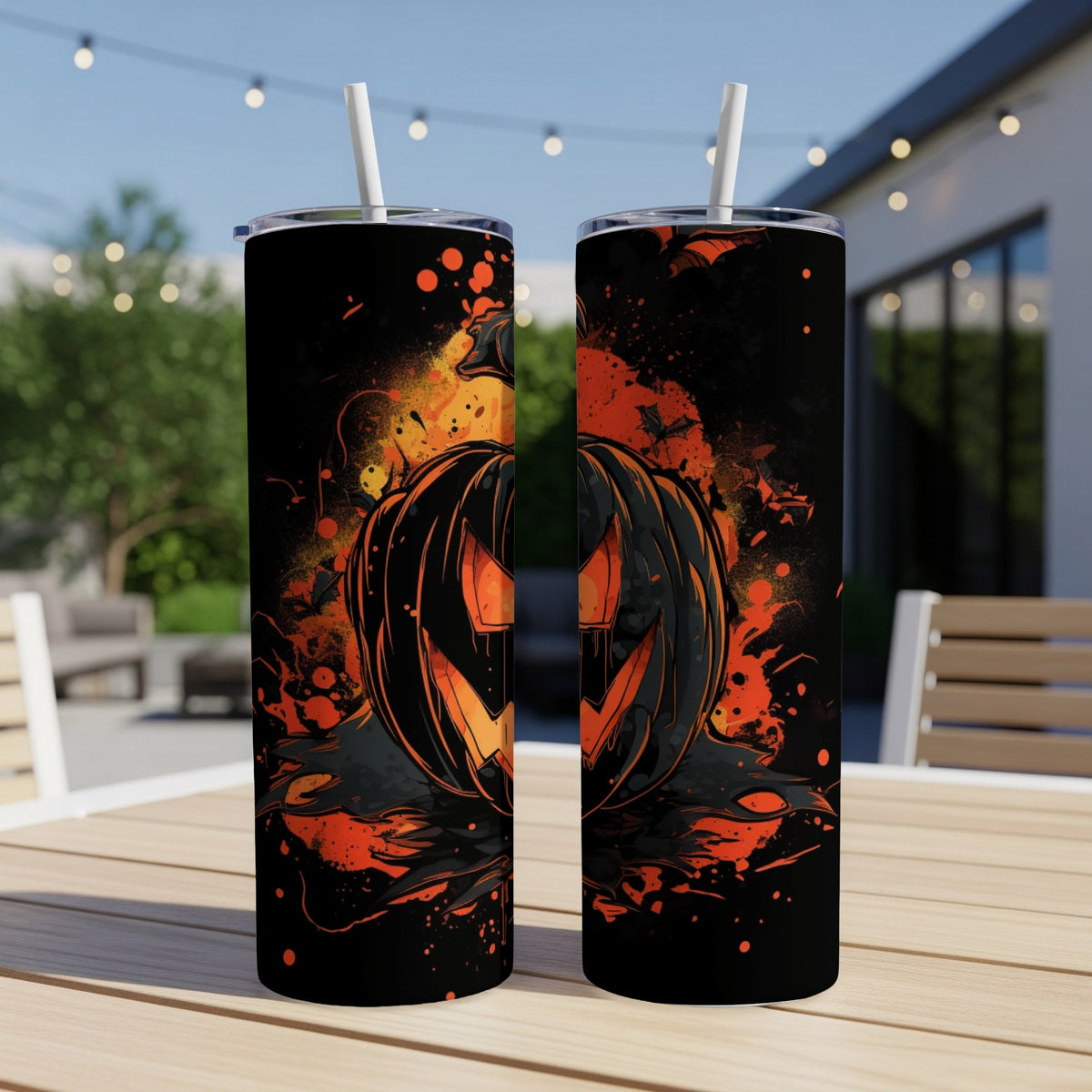 Two tumblers with a spooky jack-o'-lantern design and bats, displayed outdoors.