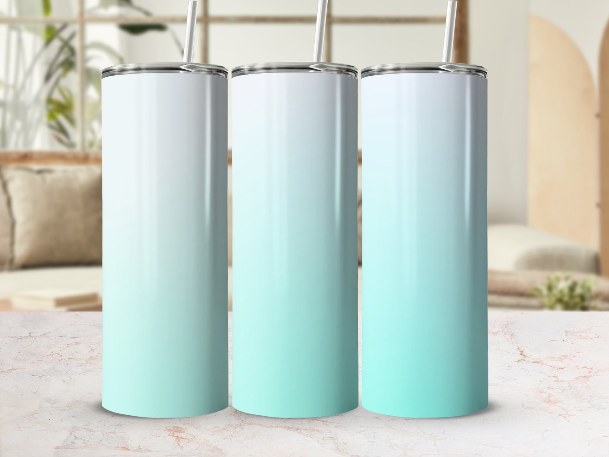 Three gradient tumblers with straws on a marble surface, blurred background.