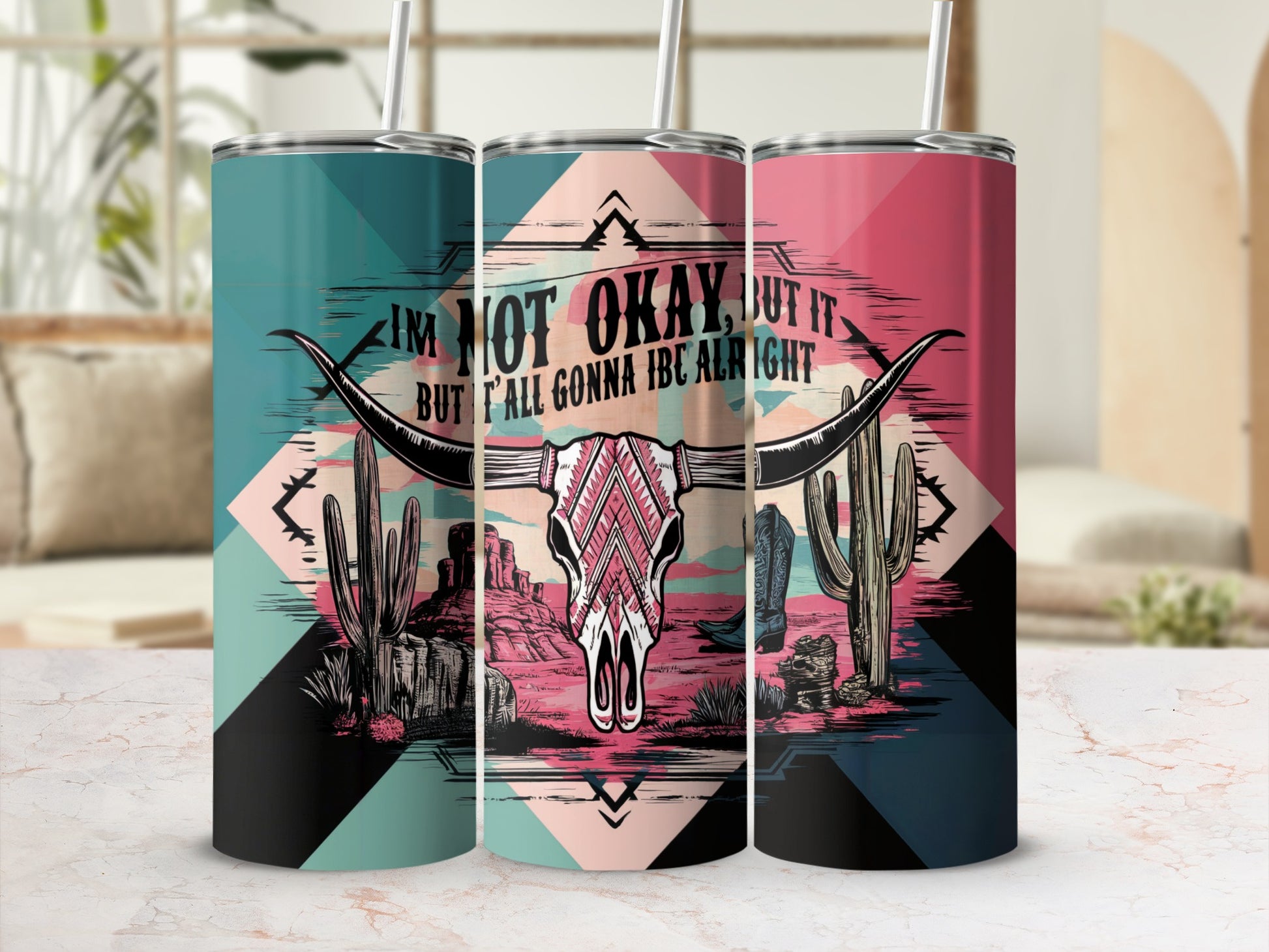Tumblers with a western desert design and the text "I'm not okay, but it but y'all gonna be alright".