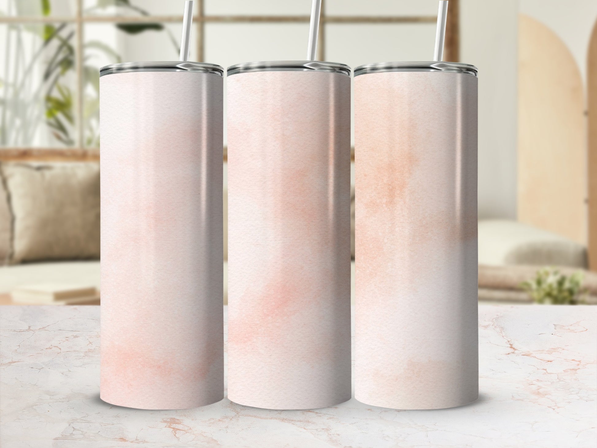 Three pink watercolor tumblers with straws on a white marble surface.