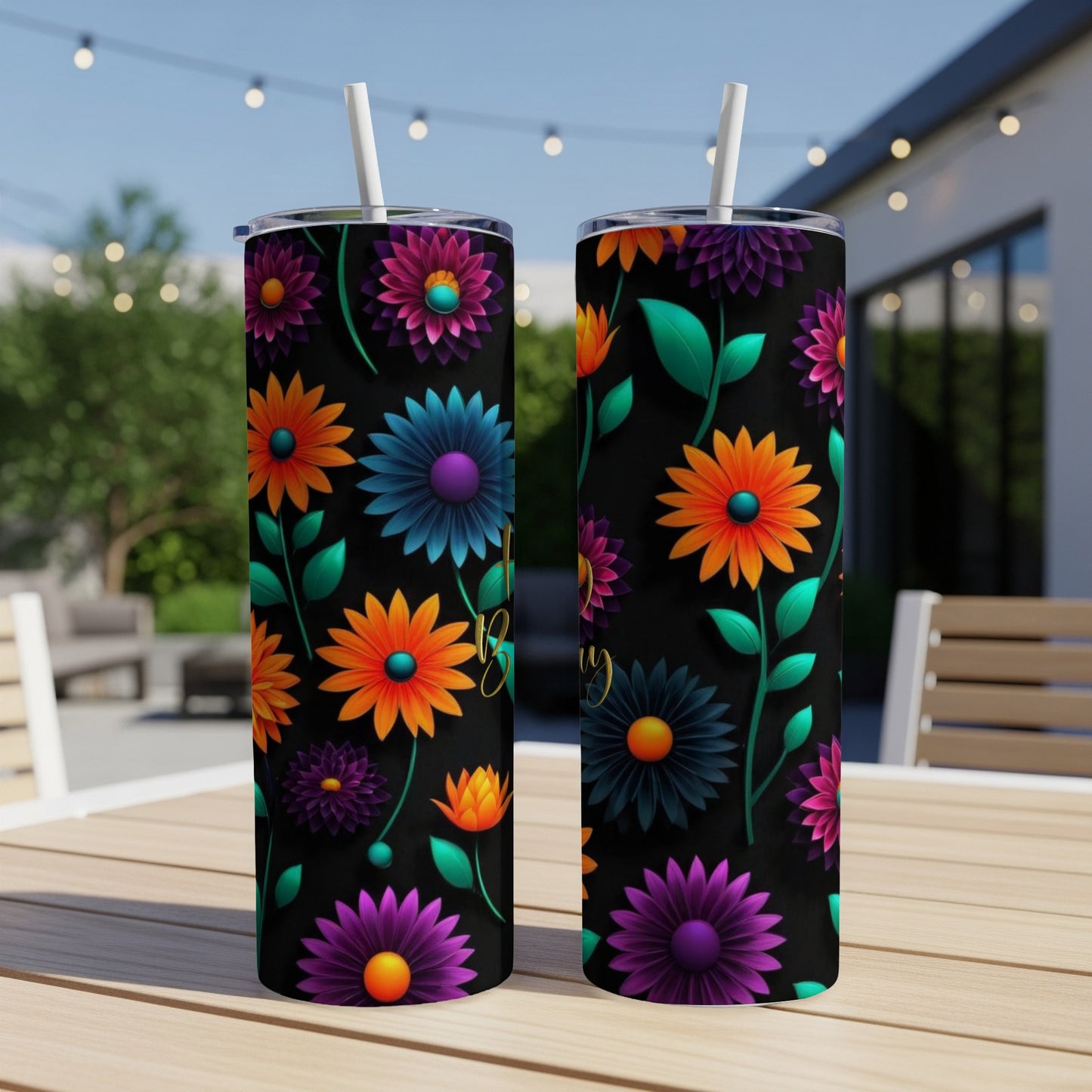 Two black tumblers with colorful floral patterns and text on a table.