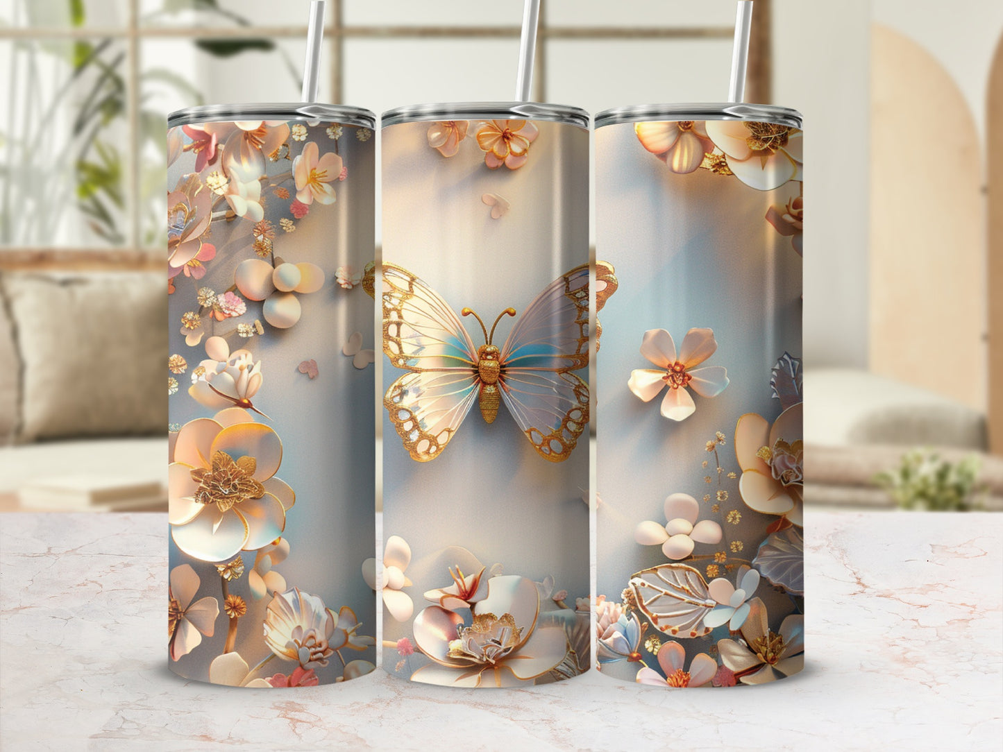 Three tumblers with floral and butterfly designs on a marble countertop.