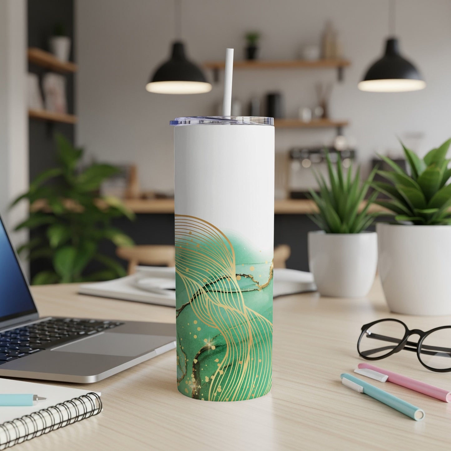 White tumbler with green marble and gold abstract design and straw.