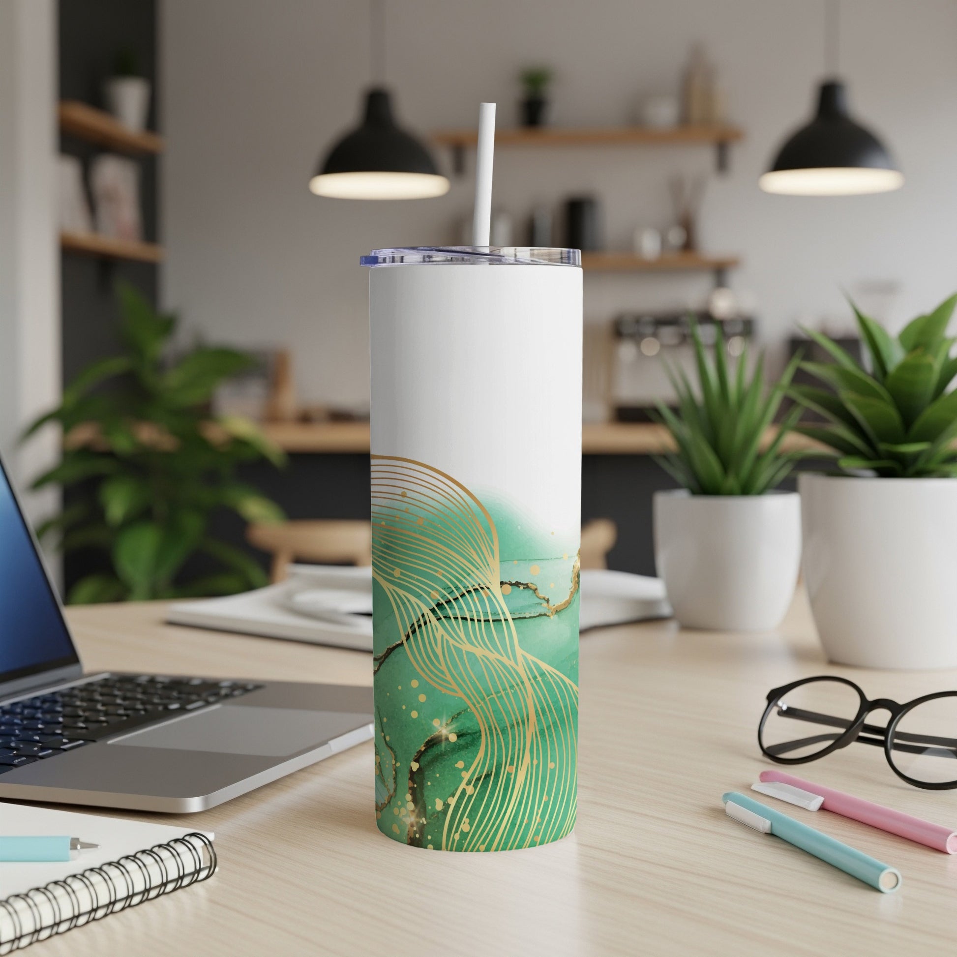 White tumbler with green marble and gold abstract design and straw.