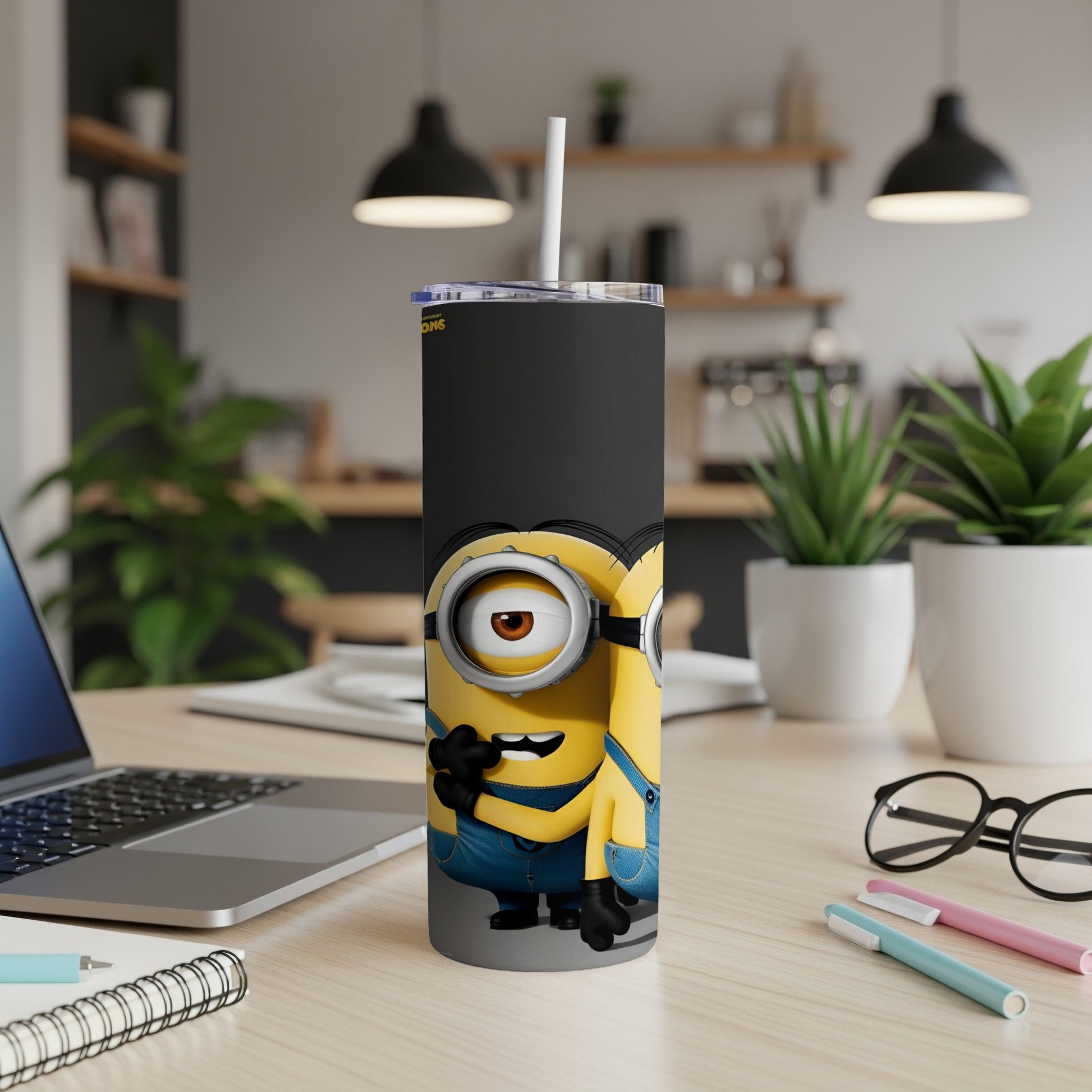 Minions characters on a black tumbler with a straw, on a desk.
