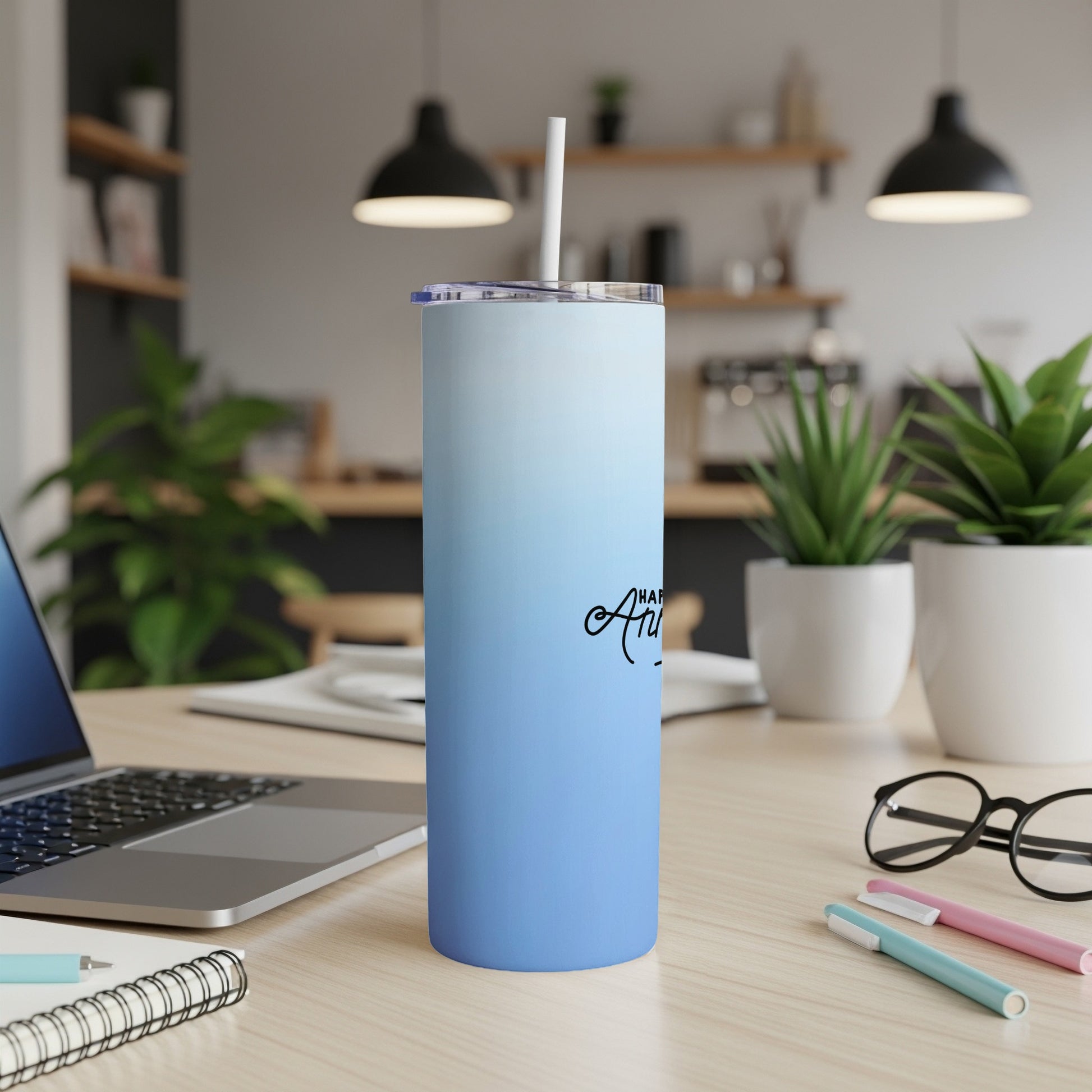 Blue ombre tumbler with "Happy Anniversary" text and straw on desk.