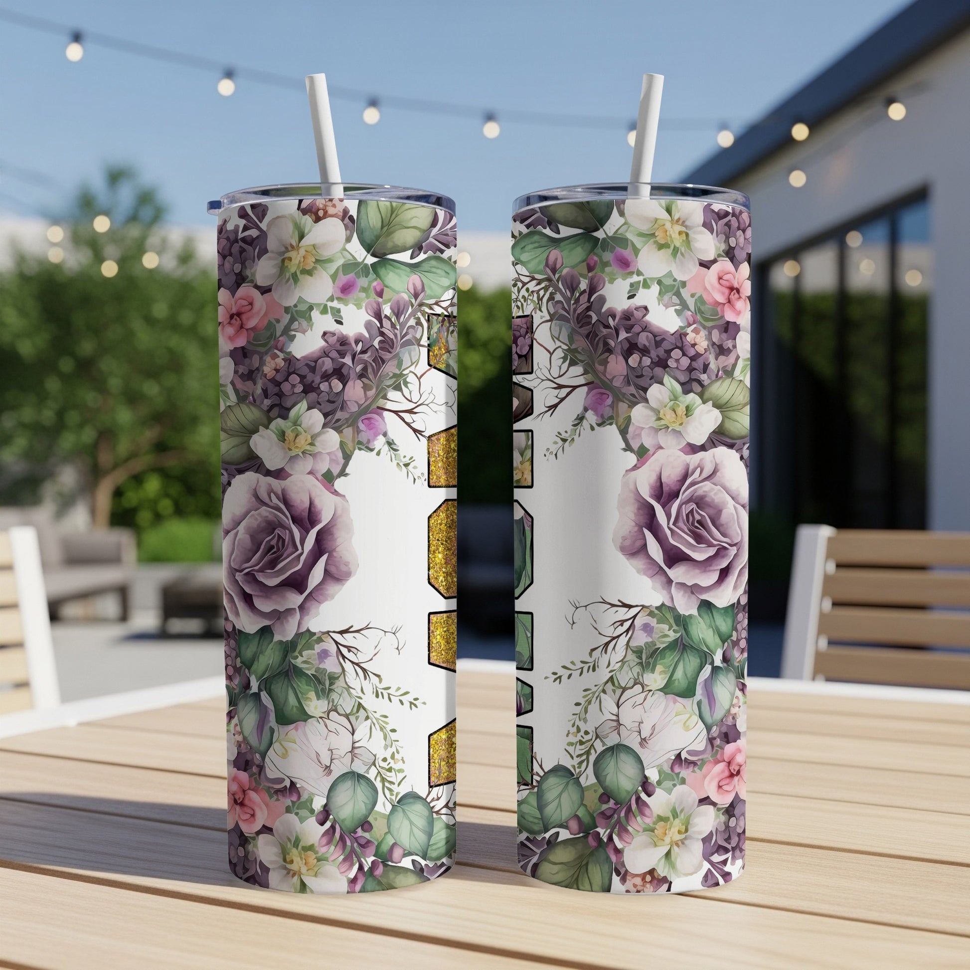Two floral tumblers with gold glitter "Mama" text sit on a patio table.