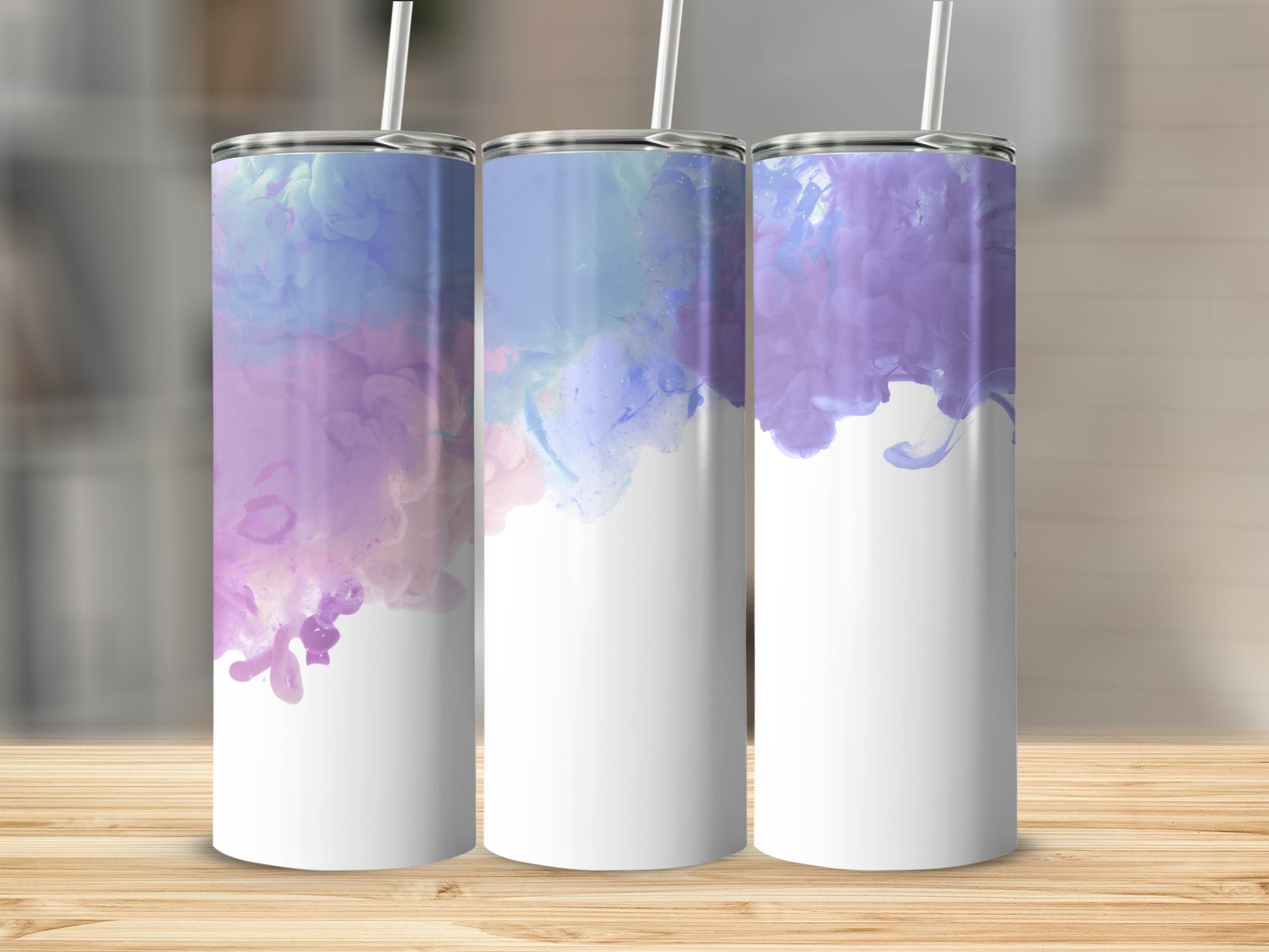 Three white tumblers with purple and blue watercolor designs and straws.