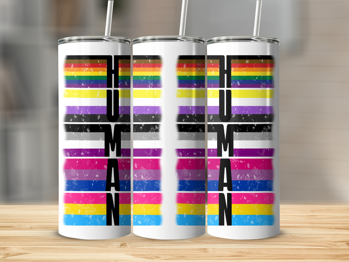 Three tumblers with "HUMAN" text and rainbow-colored stripes.