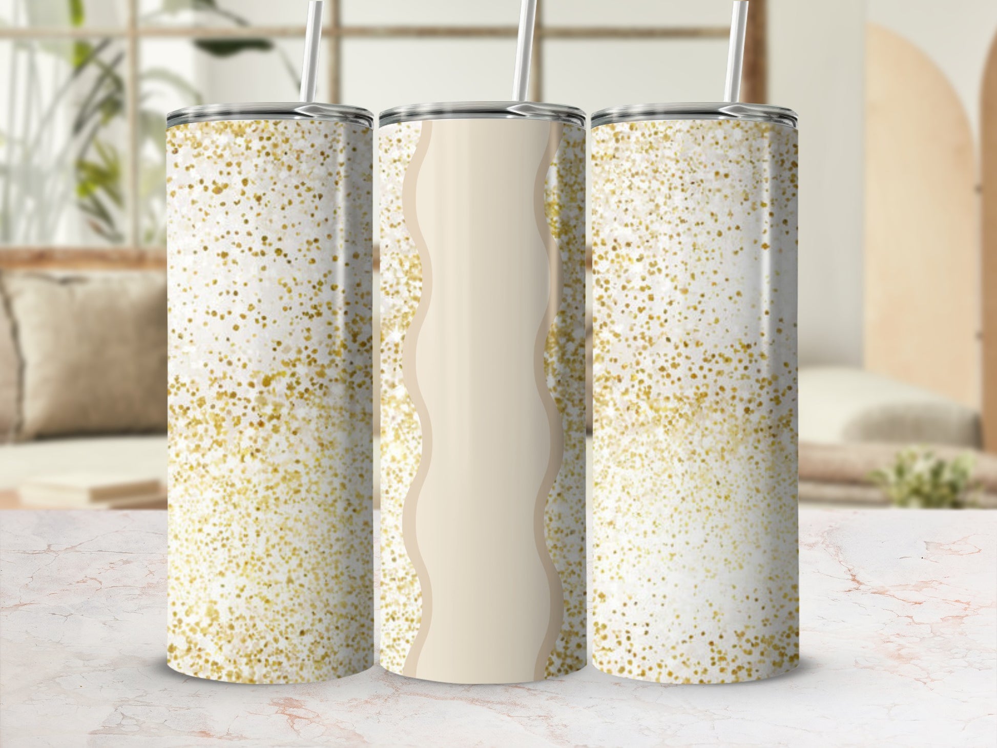 Three glitter-covered tumblers with straws on a marble surface.