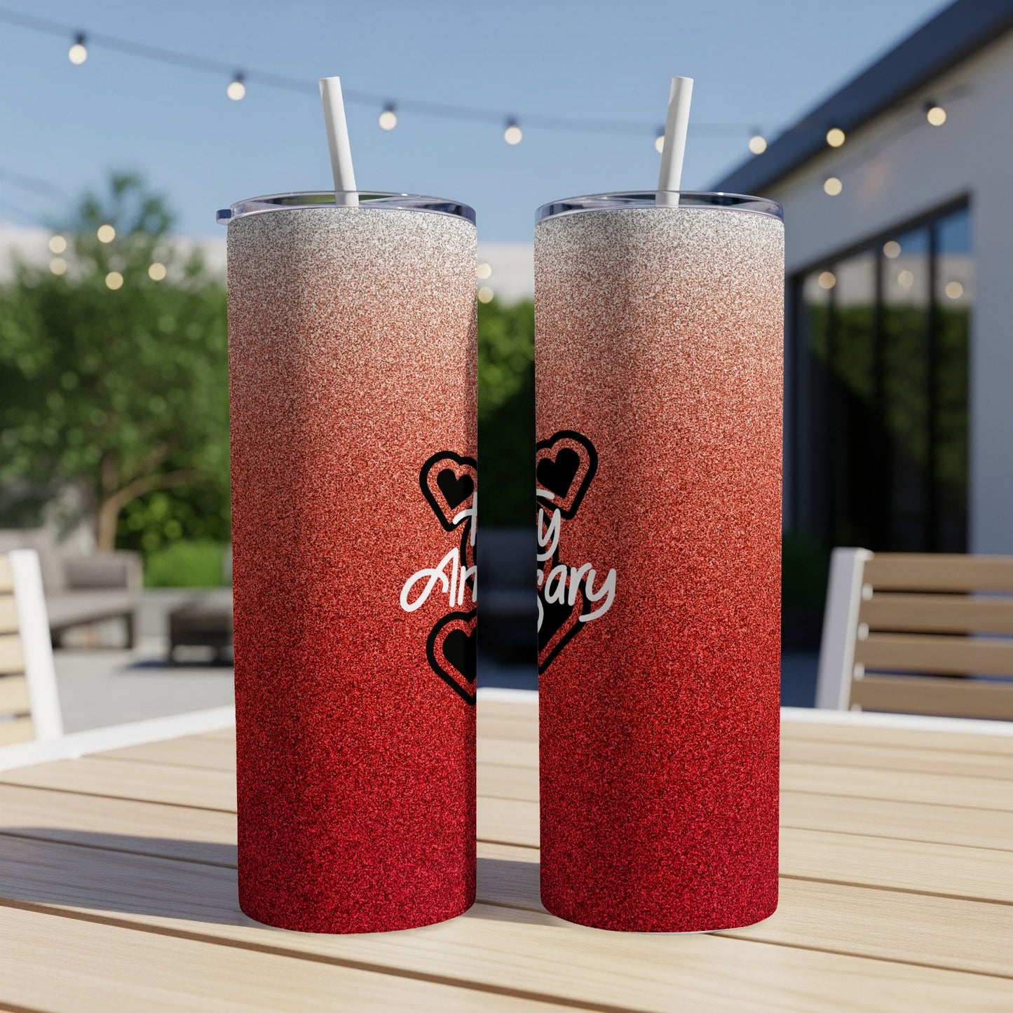 Two glitter tumblers with "Happy Anniversary" text on a table.