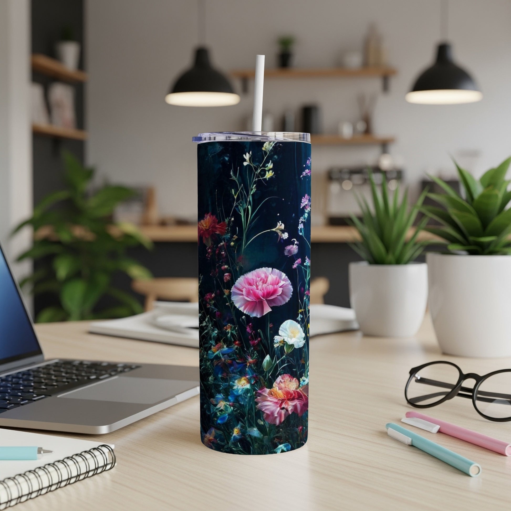 Floral patterned tumbler with straw on a wooden desk.