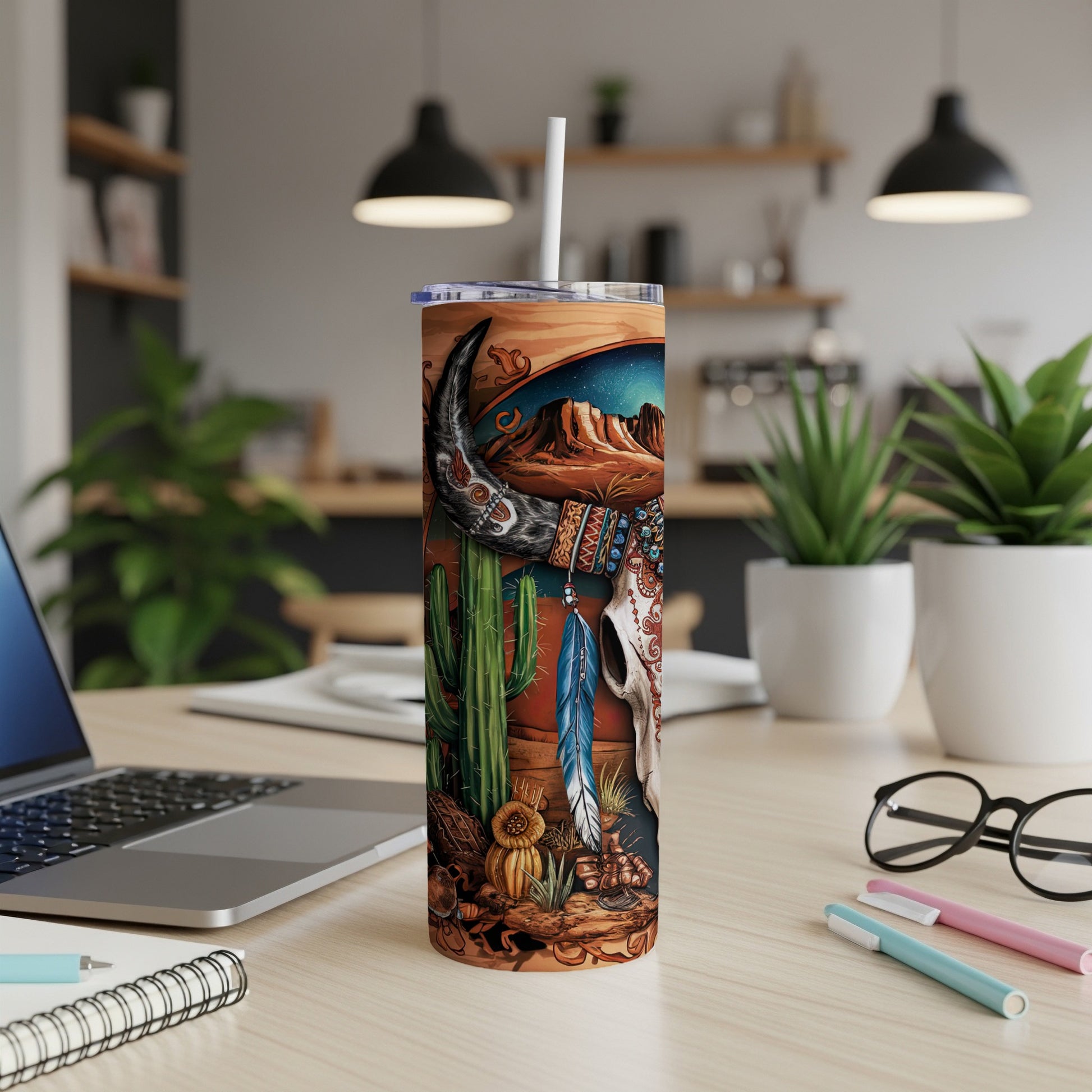 Desert scene with bull skull, feathers, and cacti on a tumbler.