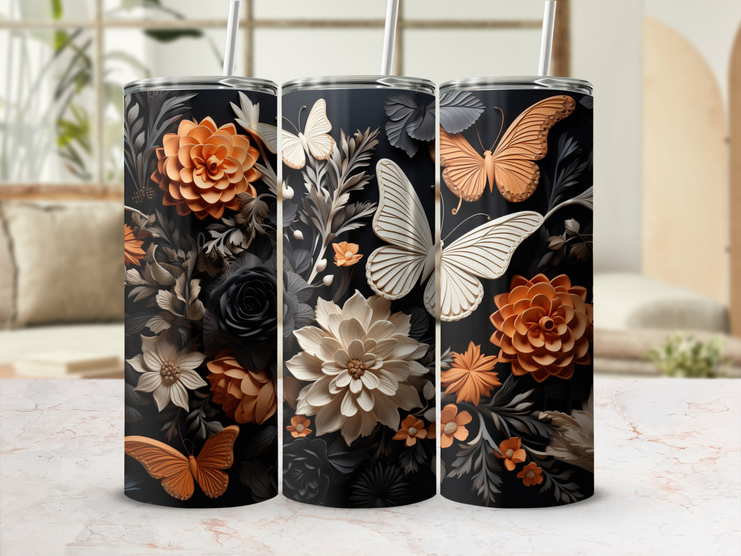 Three tumblers with floral and butterfly designs against a blurred background.