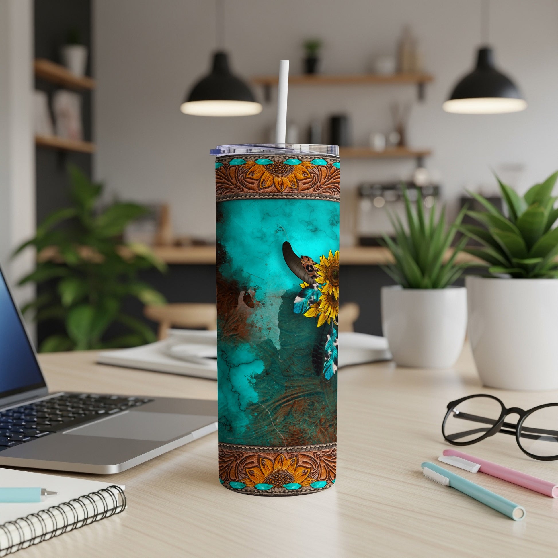 Turquoise tumbler with cow skull, sunflowers, and western patterns.