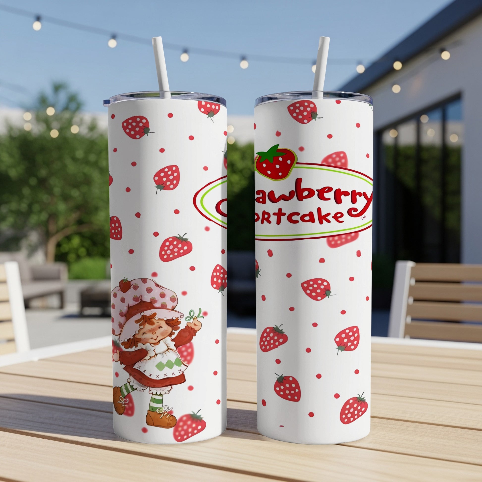 Two Strawberry Shortcake tumblers with strawberry pattern, sitting on a table.