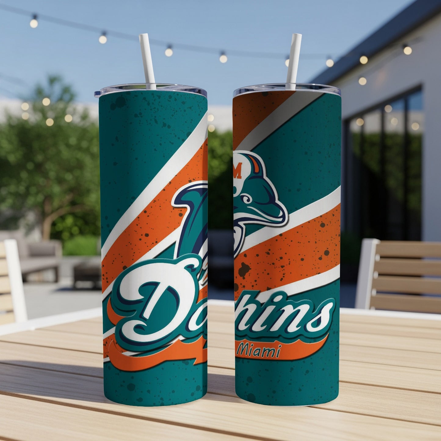Miami Dolphins tumblers with straws and team logo on a deck table.