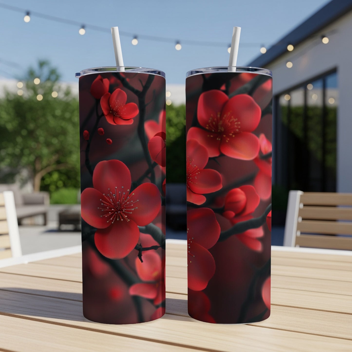Two red cherry blossom tumblers on a wooden table outdoors.