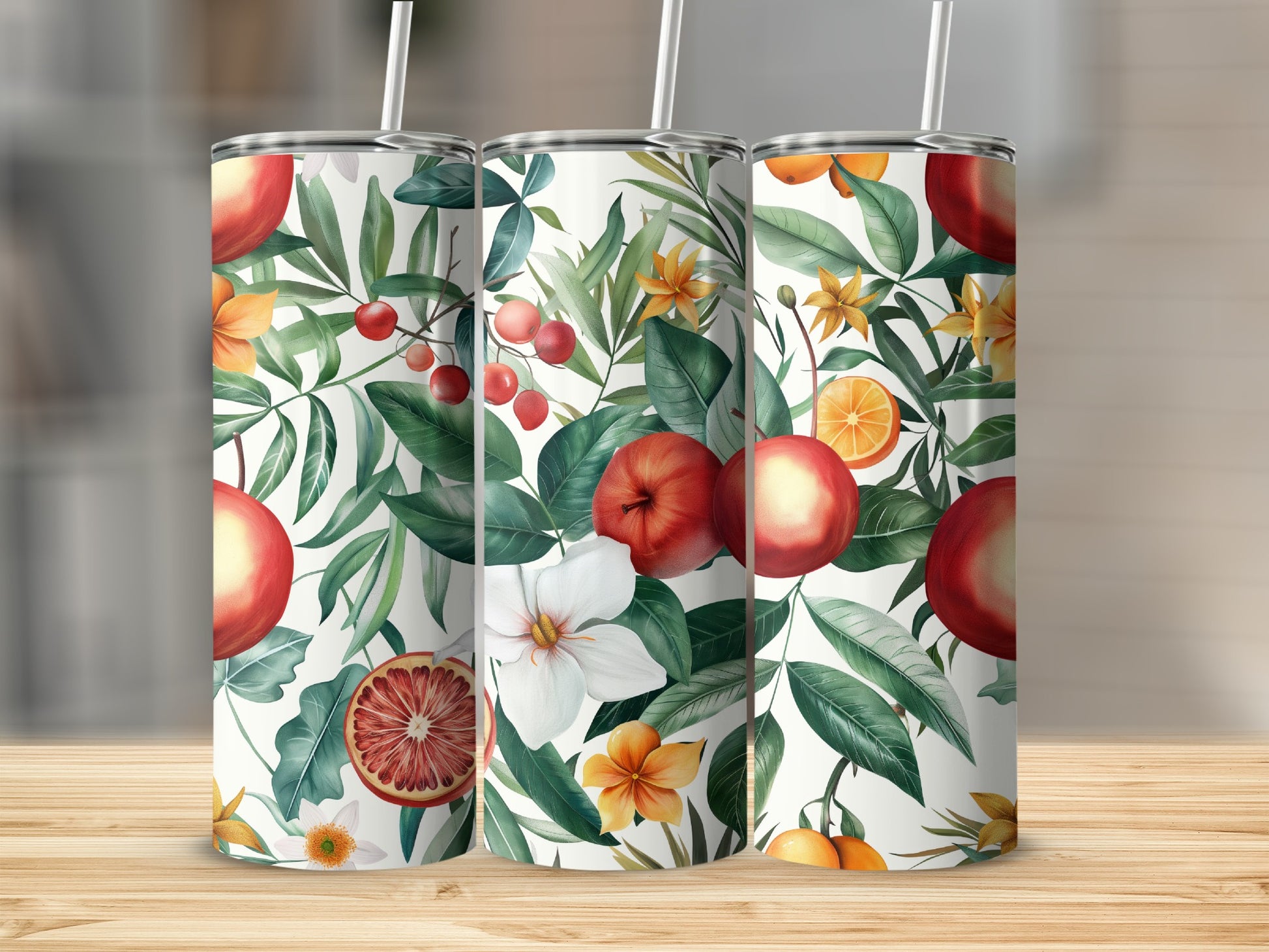 Three tumblers with a pattern of oranges, apples, and white flowers on a wooden surface.