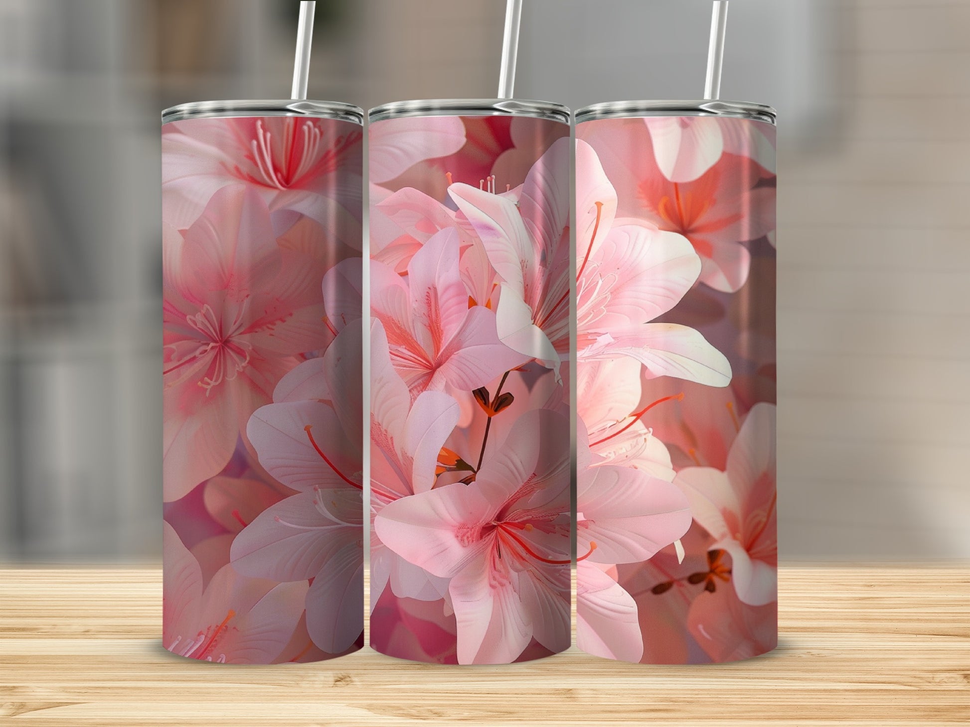 Pink floral pattern on three stainless steel tumblers with straws.