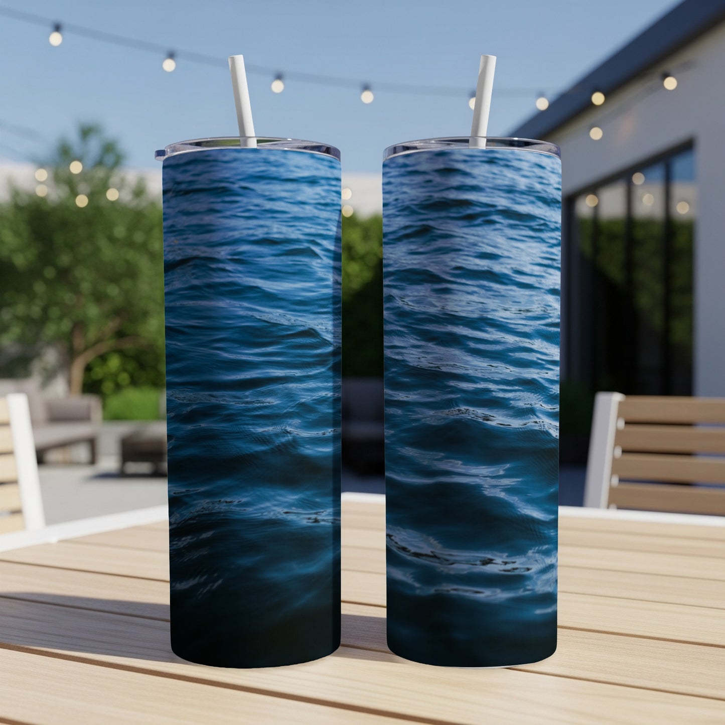 Two tumblers with a deep blue water ripple pattern sit on a wooden table.