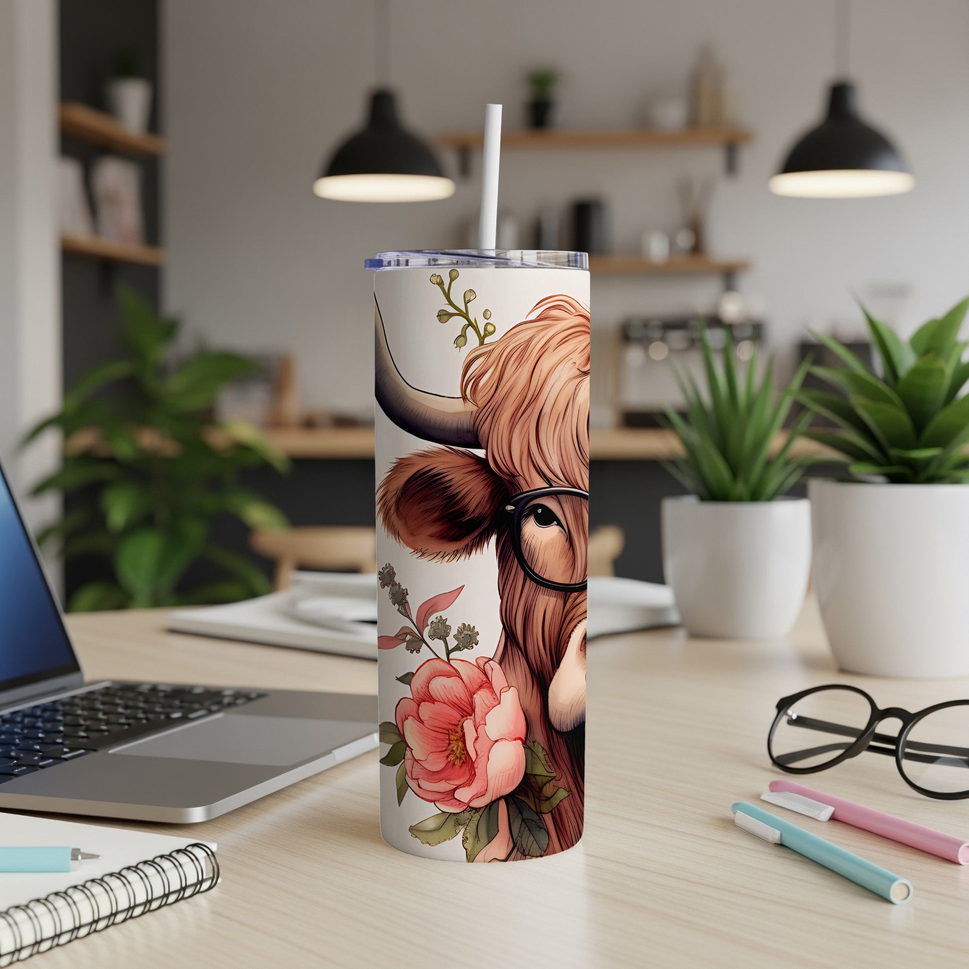 Highland cow illustration with glasses and floral accents on a white tumbler.
