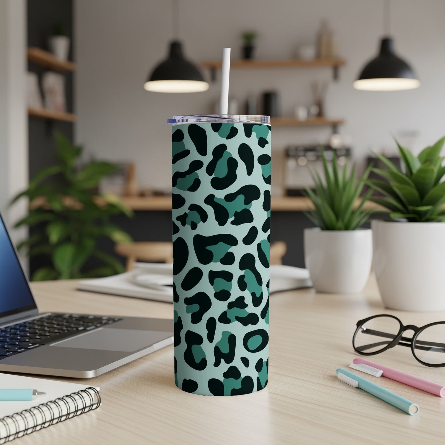 Light teal tumbler with a dark green leopard print pattern and straw.