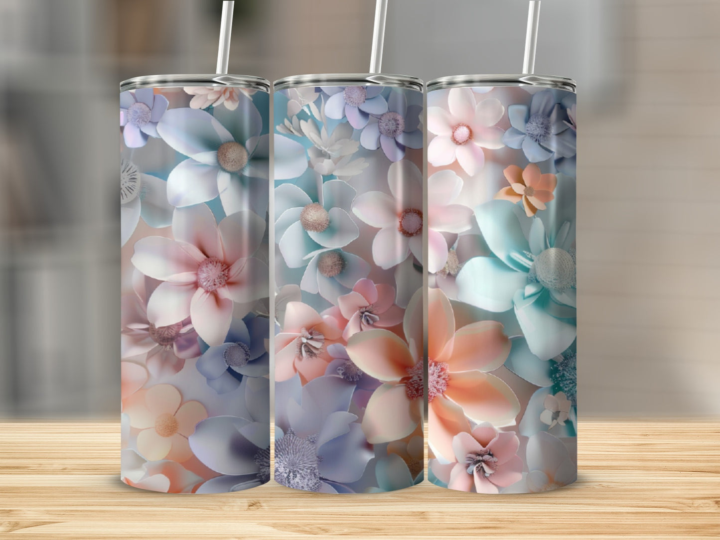 Three tumblers with pastel floral designs and straws.
