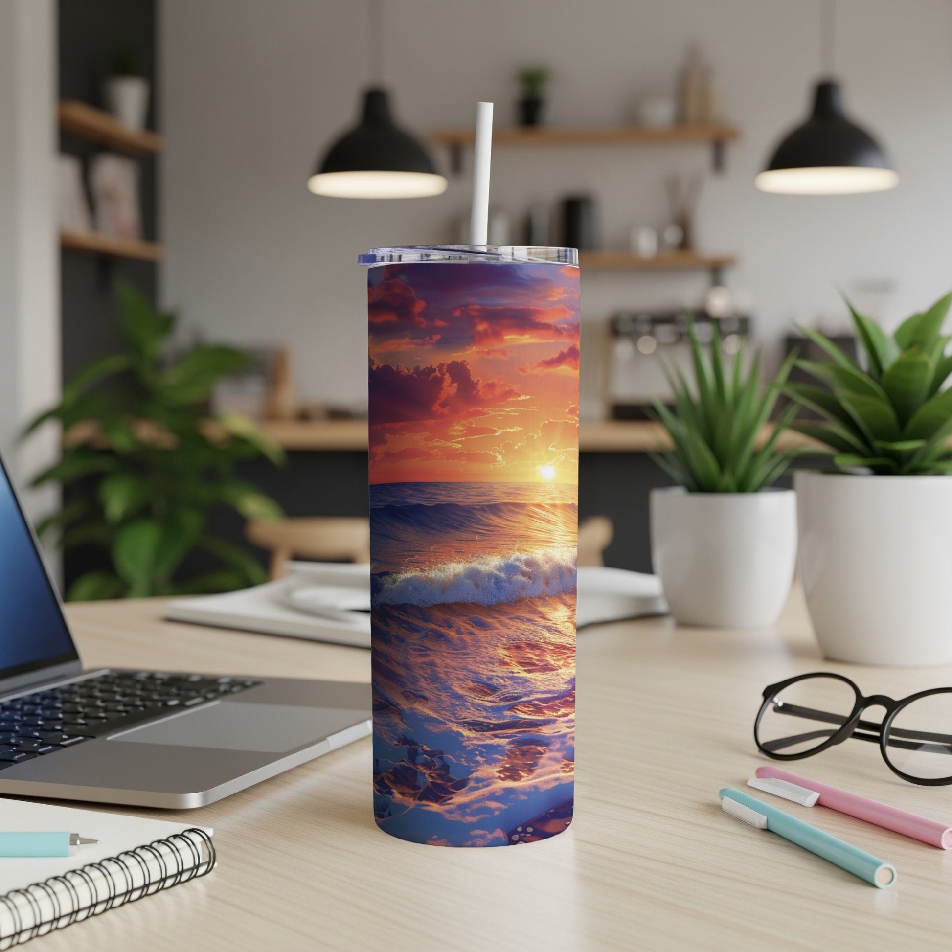 Ocean sunset with waves on a white tumbler with straw on a desk.