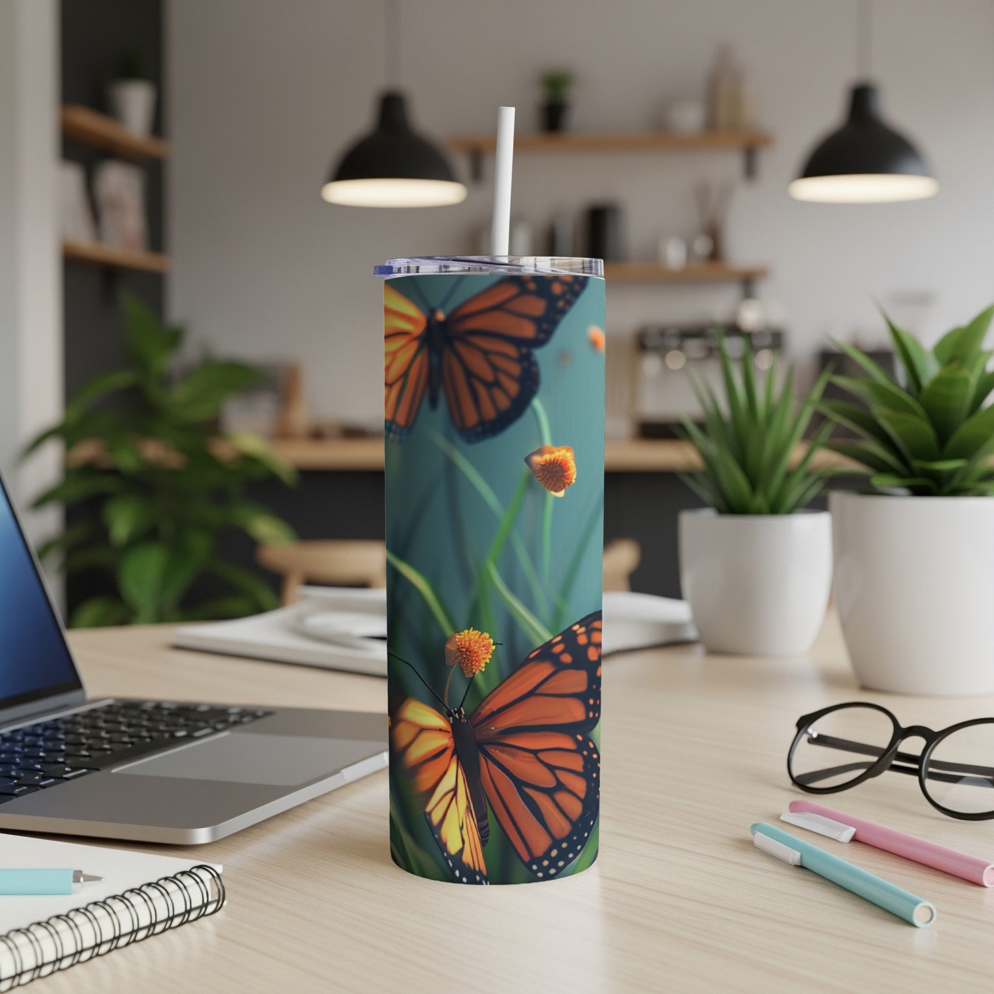 Monarch butterflies on a tall tumbler with a blue background.