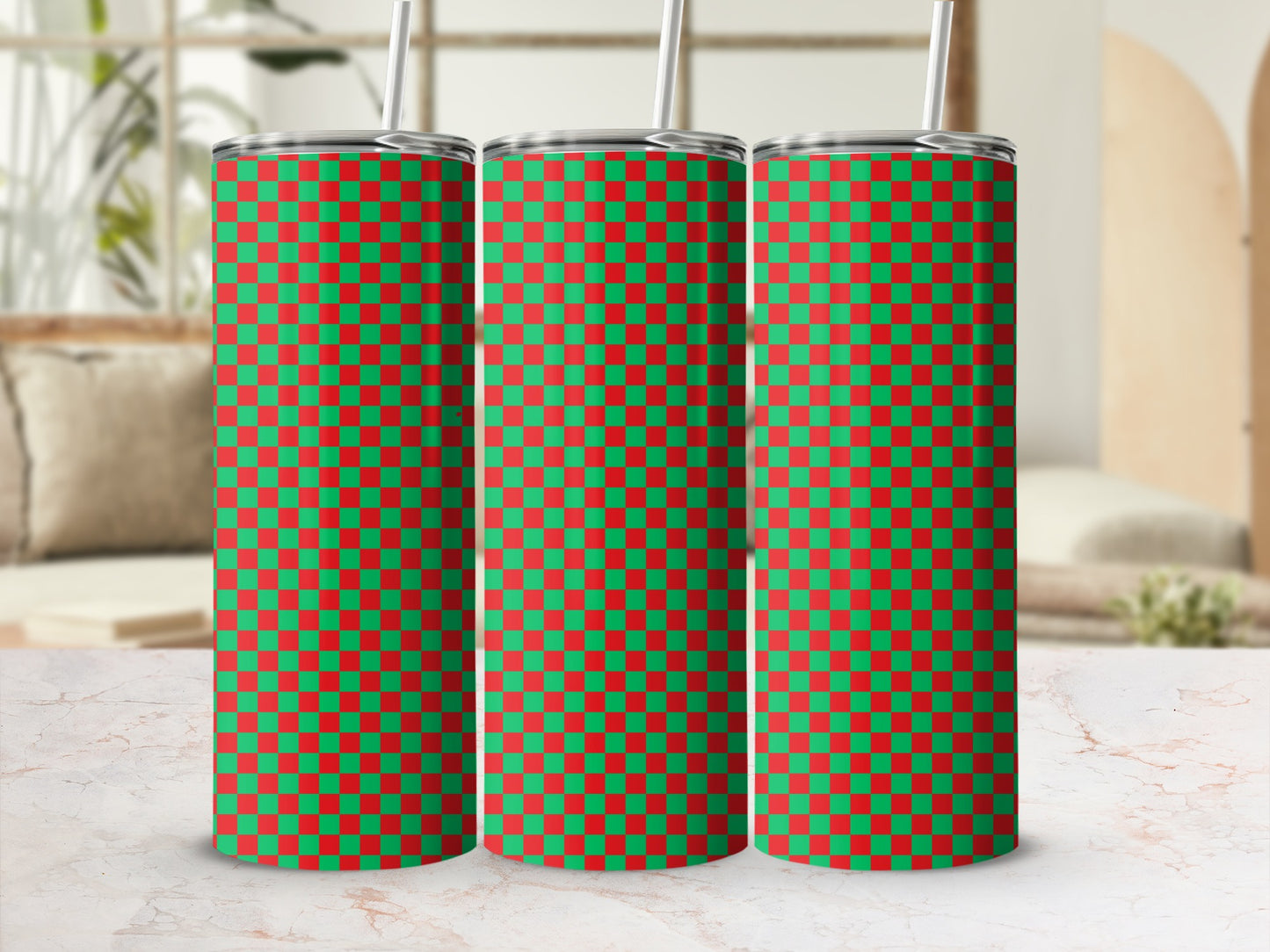 Three green and red checkered tumblers with straws on a marble surface.