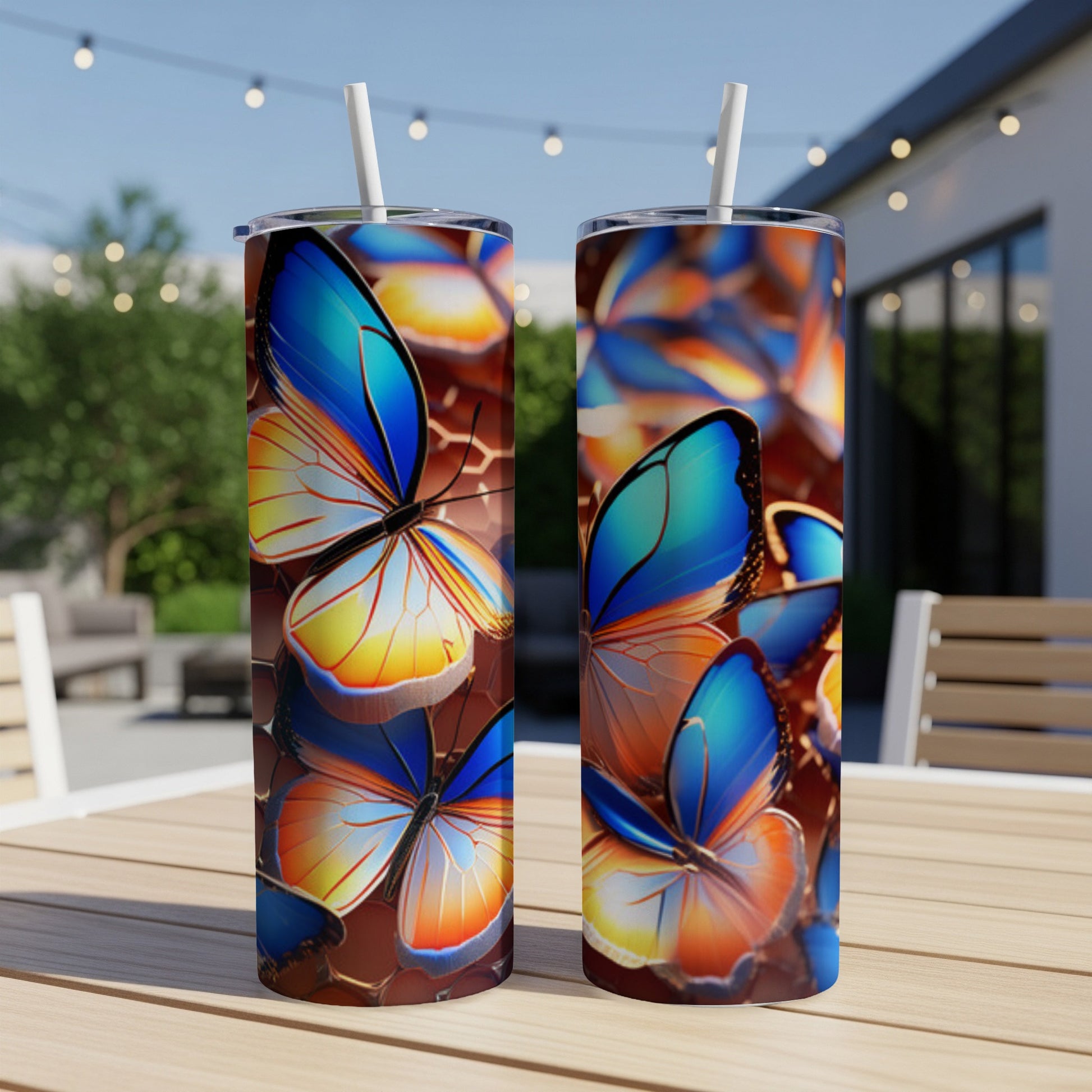Two patterned tumblers with colorful butterflies on a table outdoors.