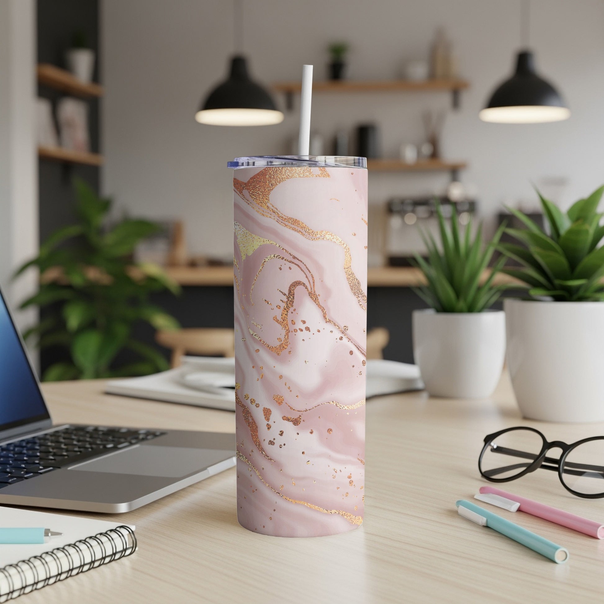 Pink marble pattern tumbler with straw on desk with laptop.