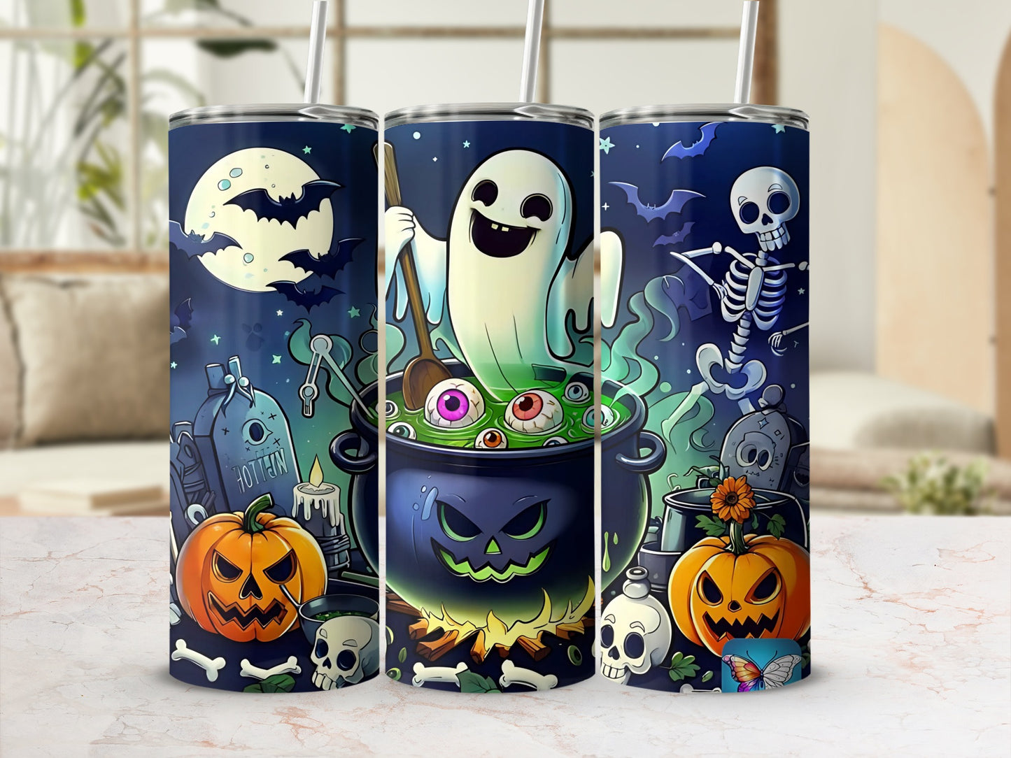 Three tumblers with Halloween art featuring a ghost, cauldron, bats, pumpkins, skeletons, and graveyard.