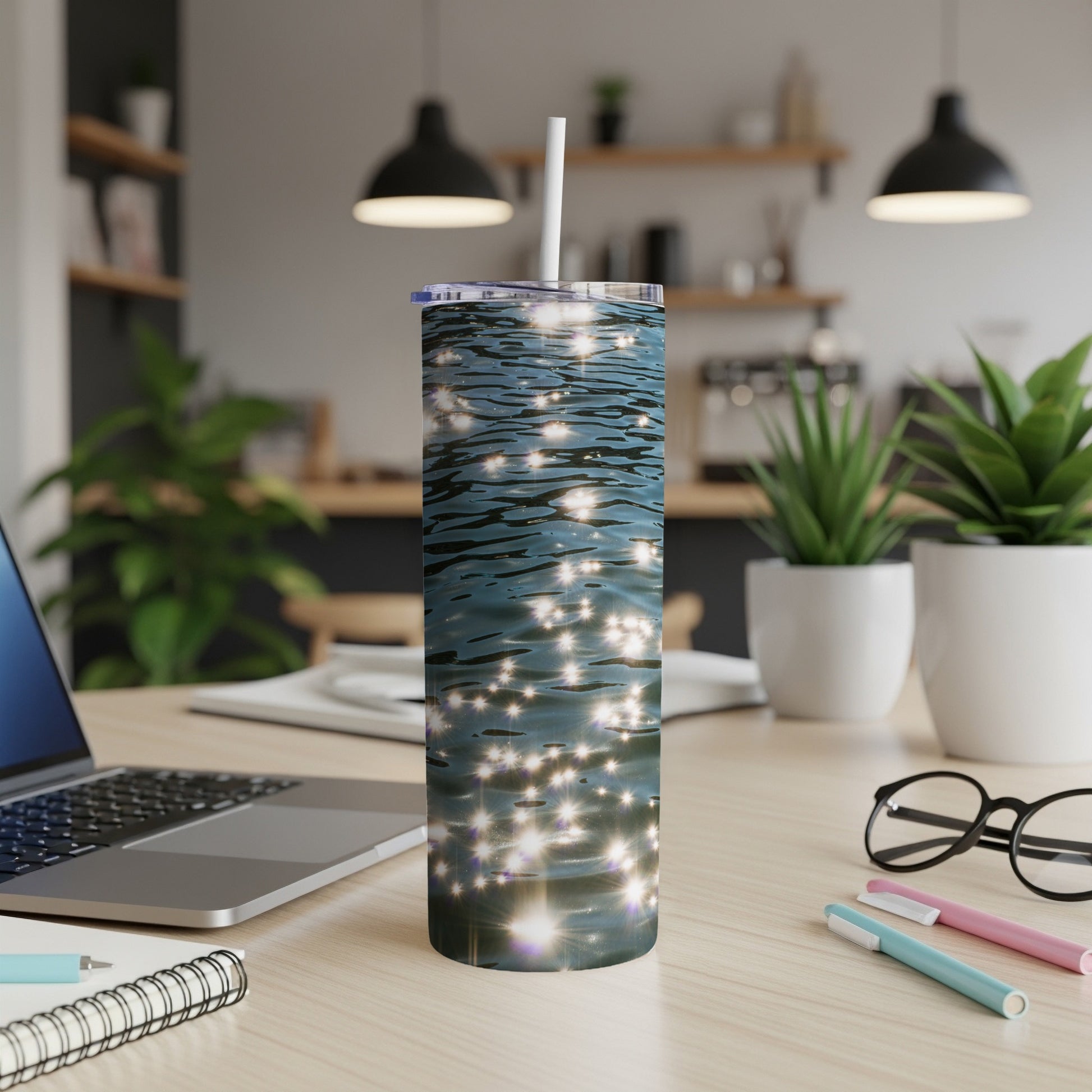 Sparkling water reflected light on a skinny tumbler, placed on a desk.