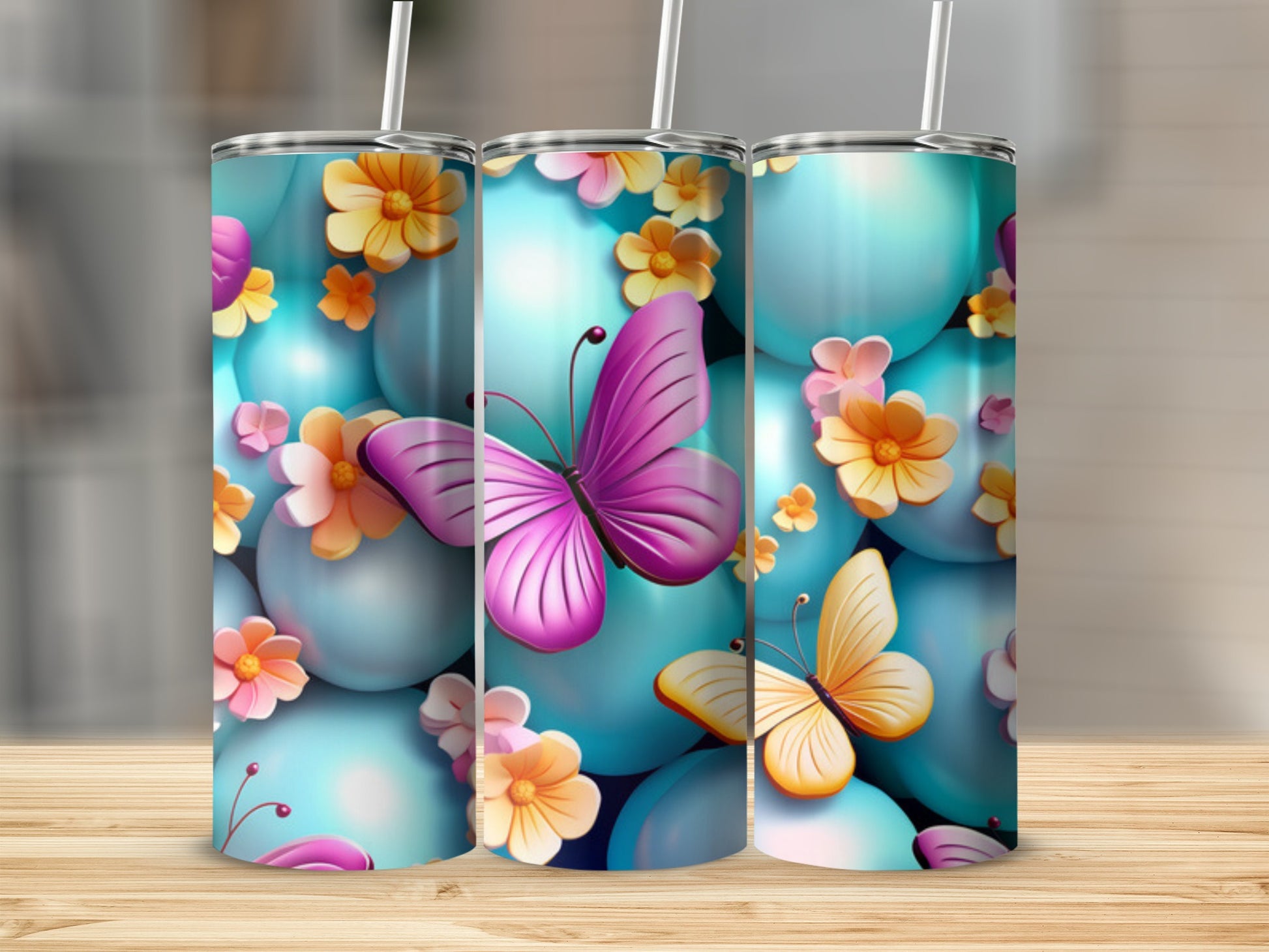 Three tumblers with butterflies and floral accents on a wooden surface.
