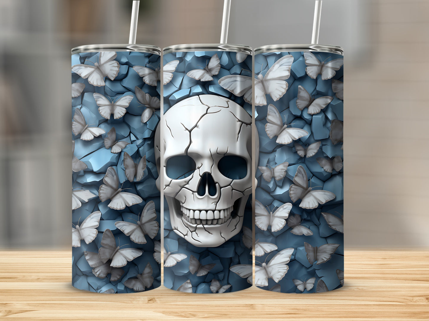 Three tumblers featuring a cracked skull with butterflies on a blue textured background.