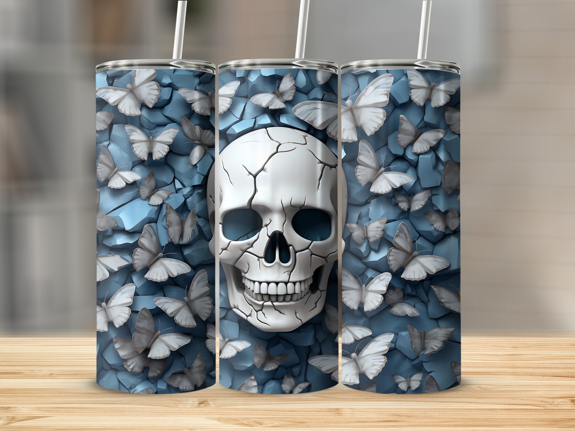 Three tumblers featuring a cracked skull with butterflies on a blue textured background.