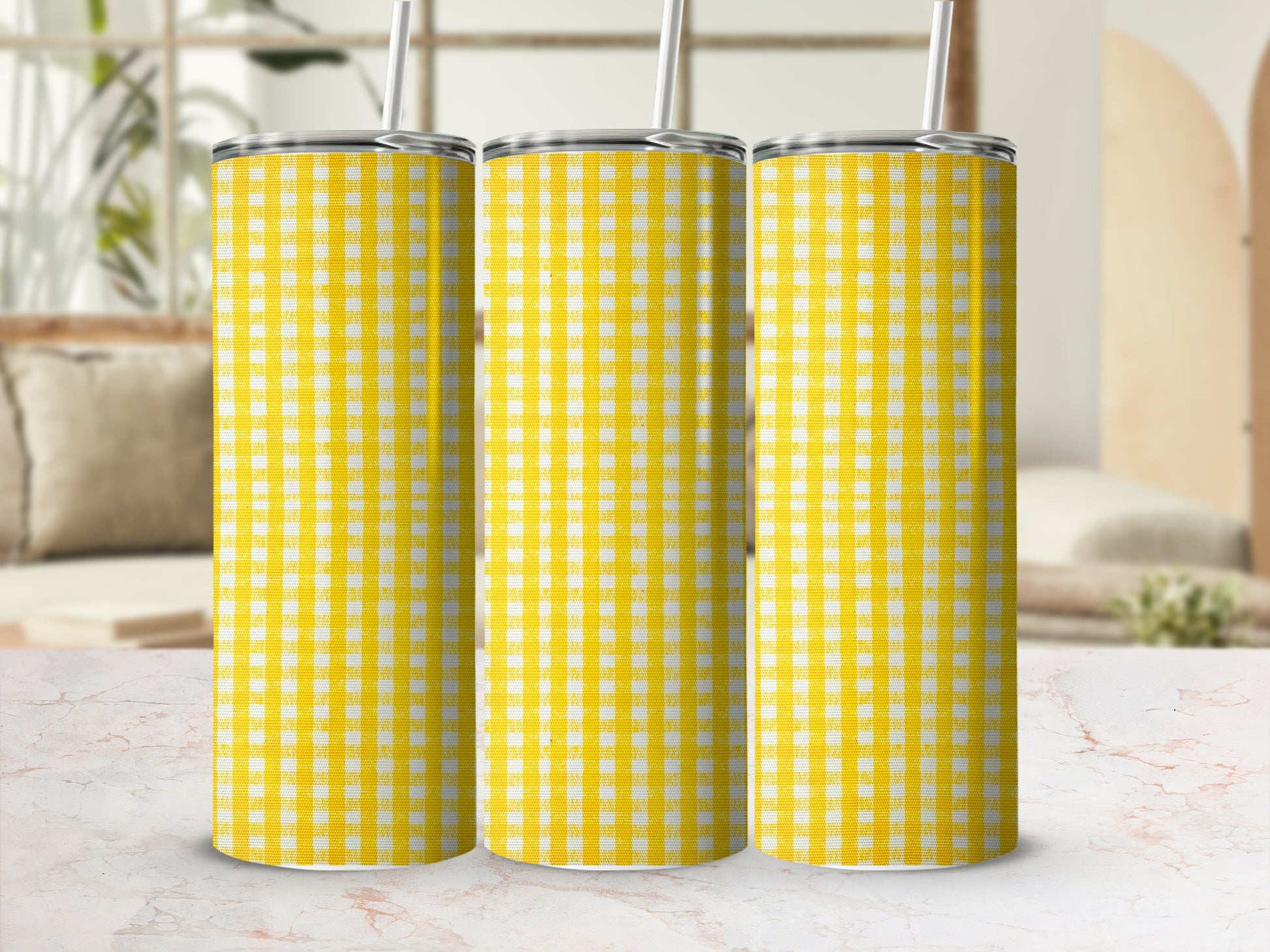 Three yellow and white checkered tumblers with straws.