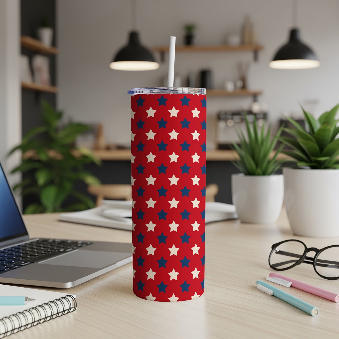 Red tumbler with repeating white and blue stars pattern with straw.