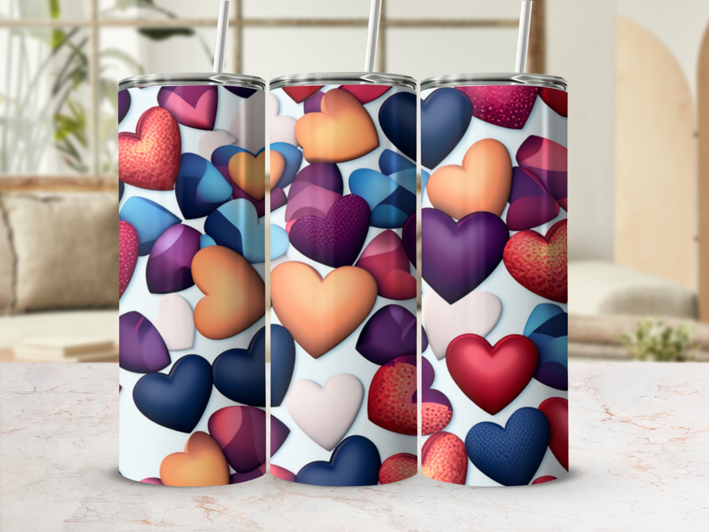 Three tumblers with colorful heart designs arranged in a row.