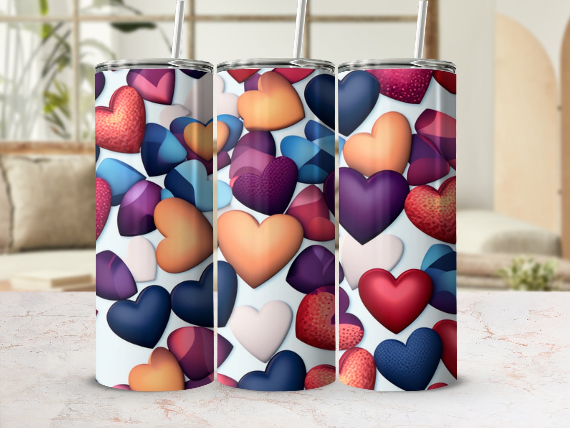 Three tumblers with colorful heart designs arranged in a row.
